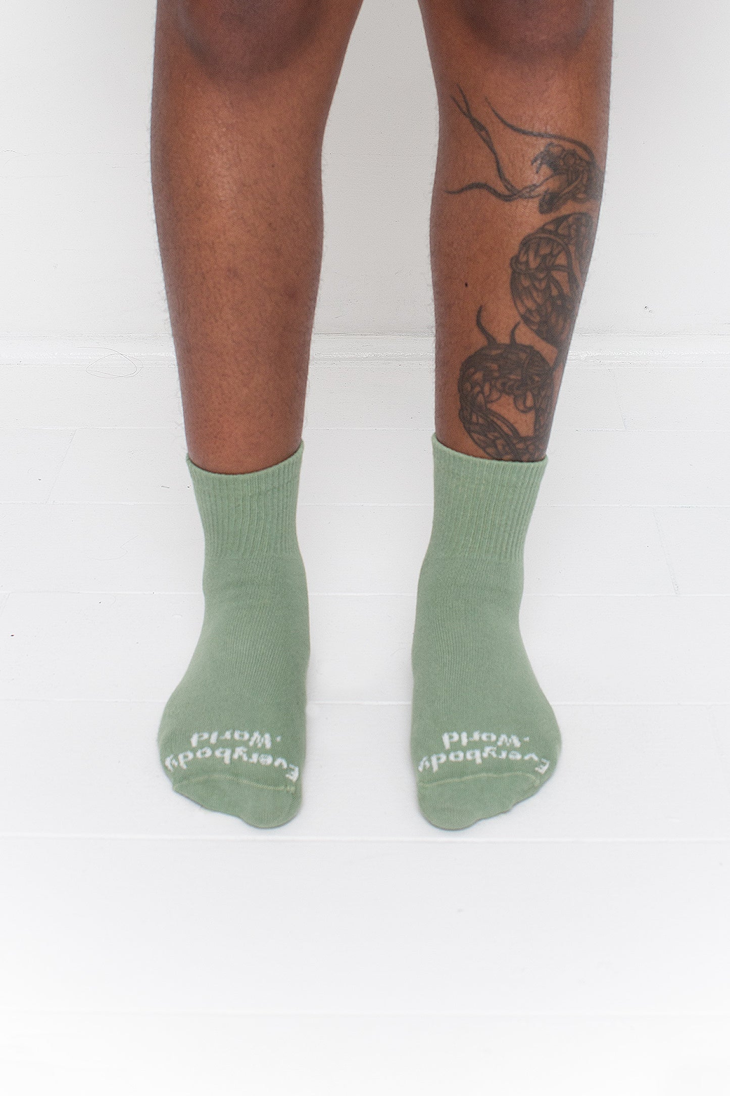 Wasabi Spring Socks, branded 'Everybody.World' in white, are ankle-high, shown on a person's lower legs.