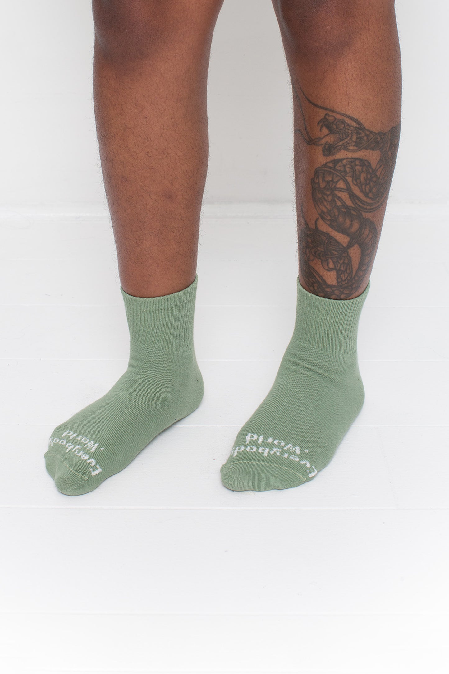 Wasabi Spring Socks, branded 'Everybody.World,' shown on a person's lower legs pointing 45-degrees.
