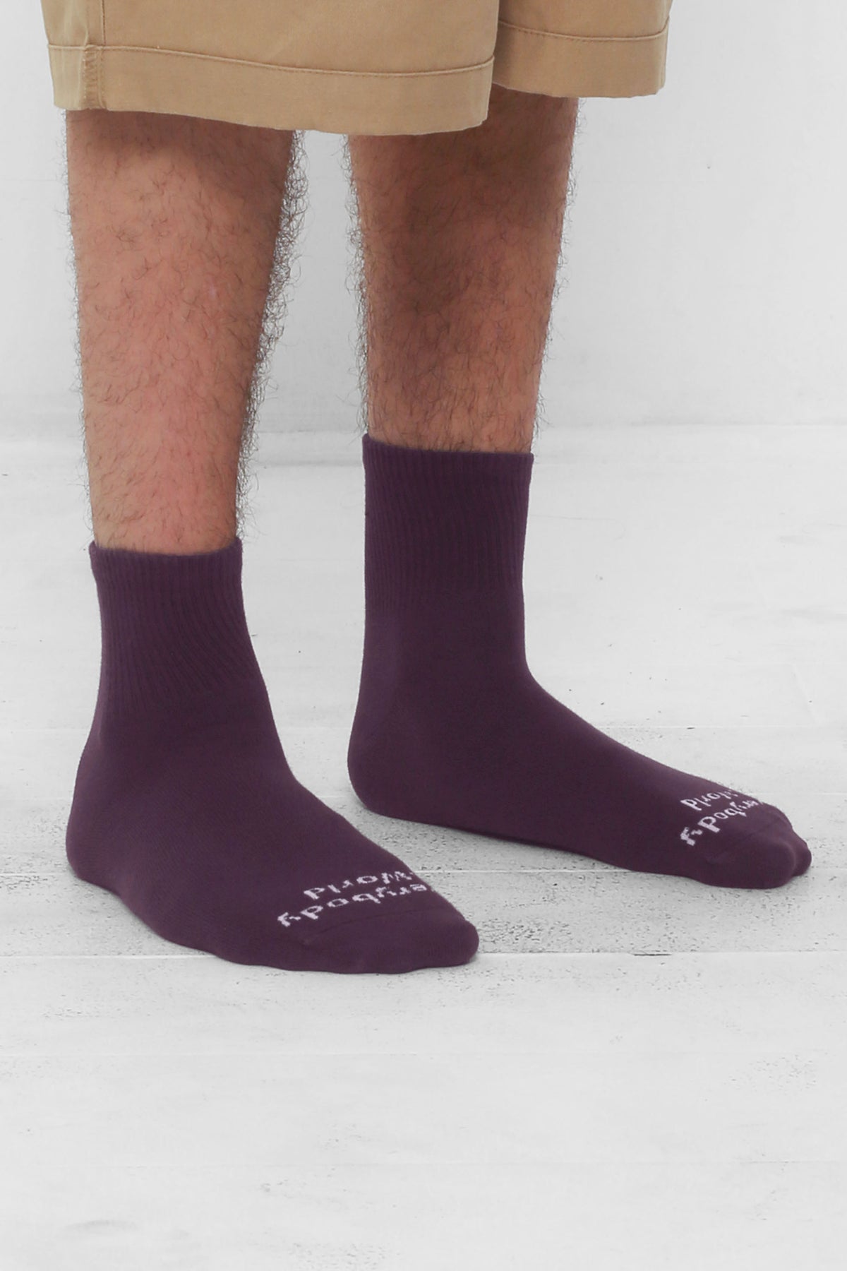 Angled view of Washed Mulberry Spring Socks, branded 'Everybody.World' in white, ankle-high, shown on lower legs.