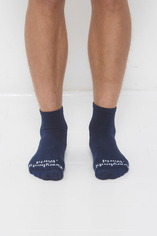 Washed Navy Spring Socks, branded 'Everybody.World' in white, ankle-high, shown on lower legs.