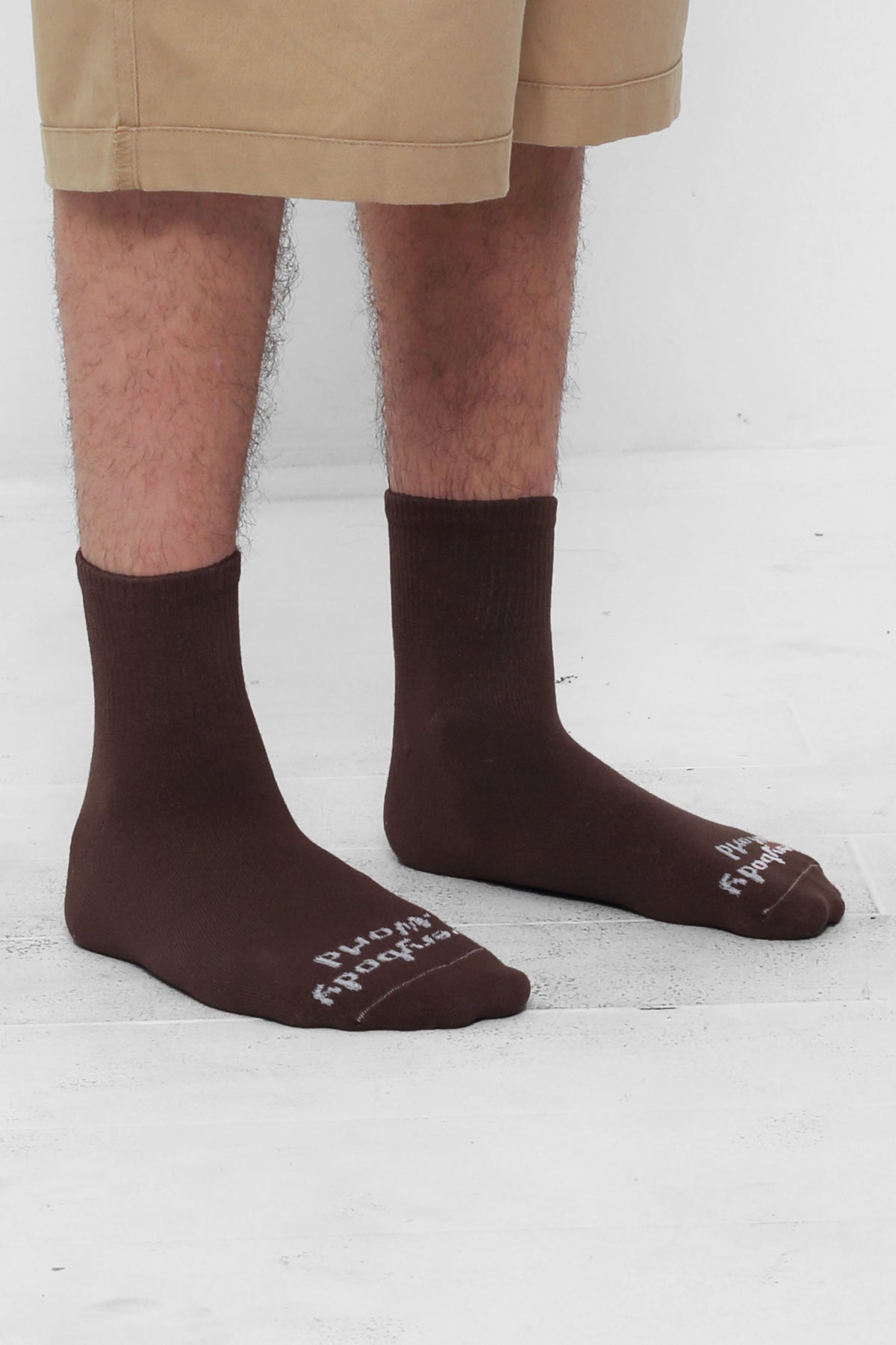 Angled view of Wet Soil Spring Socks, branded 'Everybody.World' in white, ankle-high, shown on lower legs.