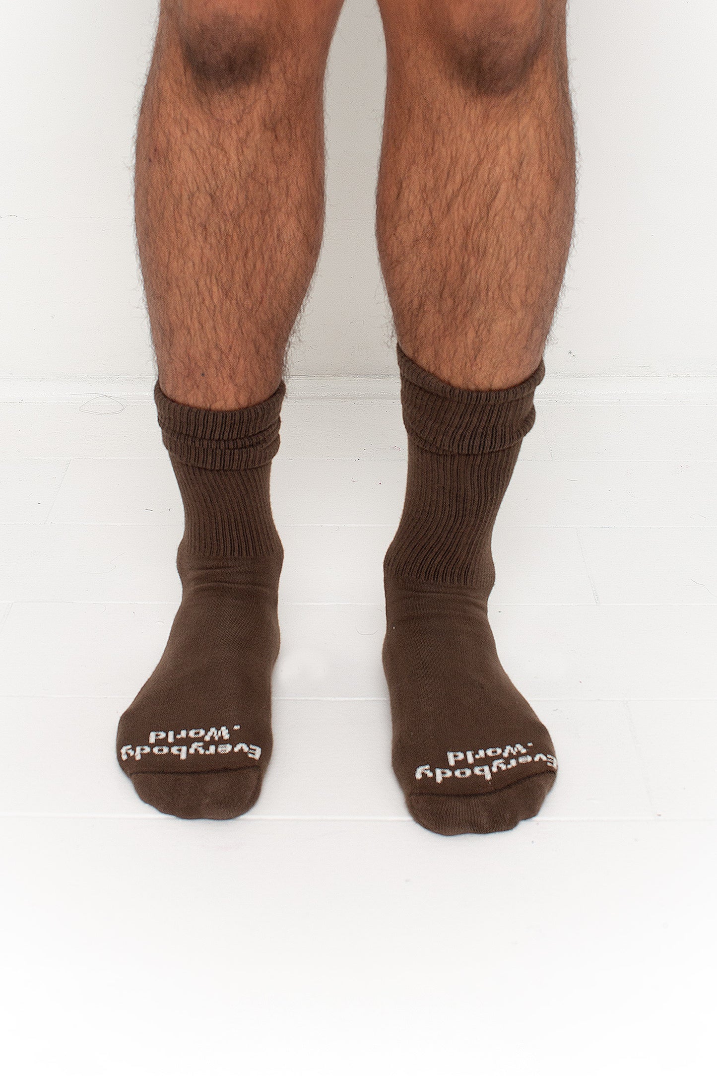 Dry Soil Squishy Socks, branded 'Everybody.World' in white at the toe, shown on a person's lower legs.