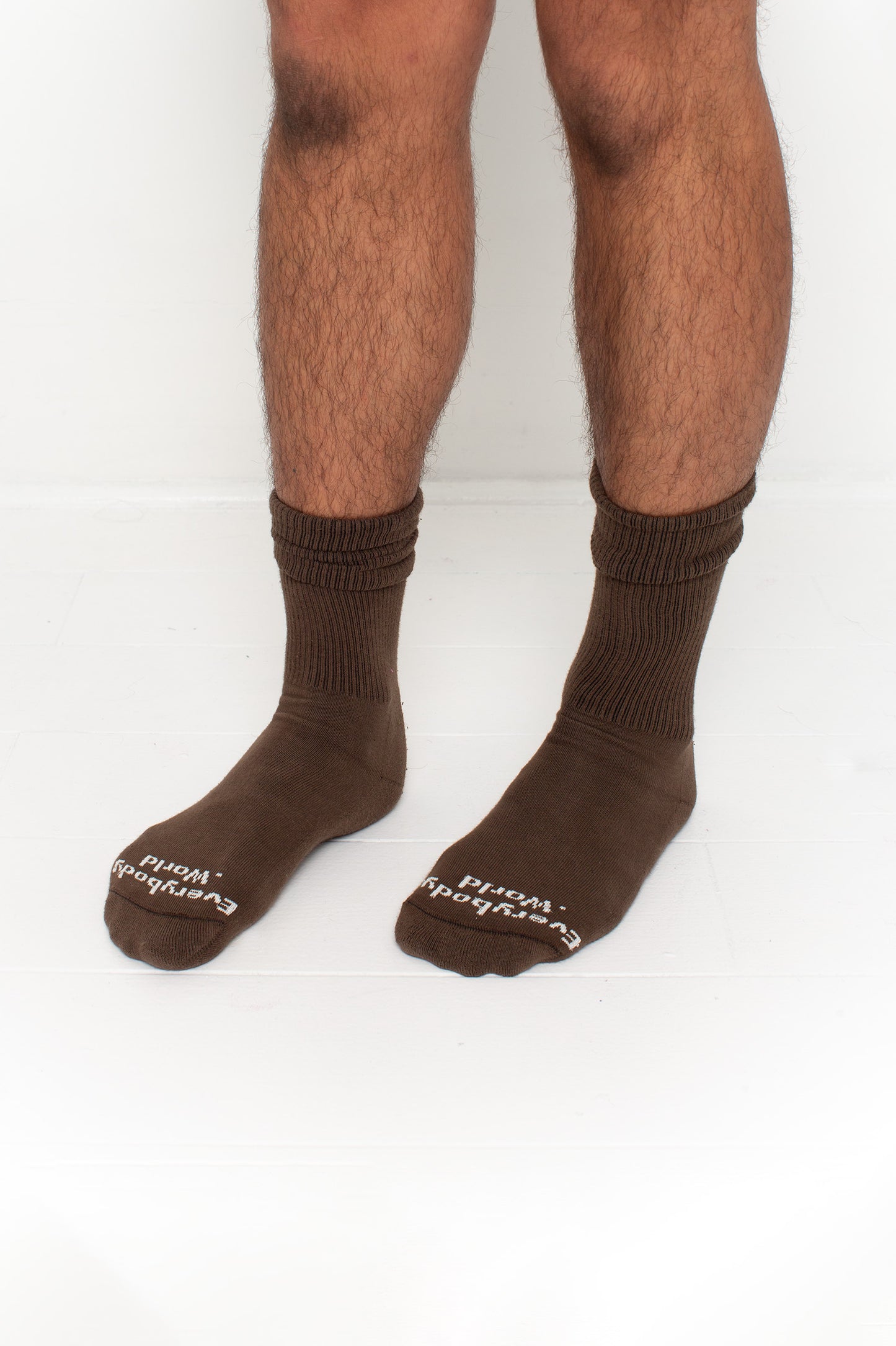 Dry Soil Squishy Socks, branded 'Everybody.World' in white at the toe, shown on a person's lower legs.