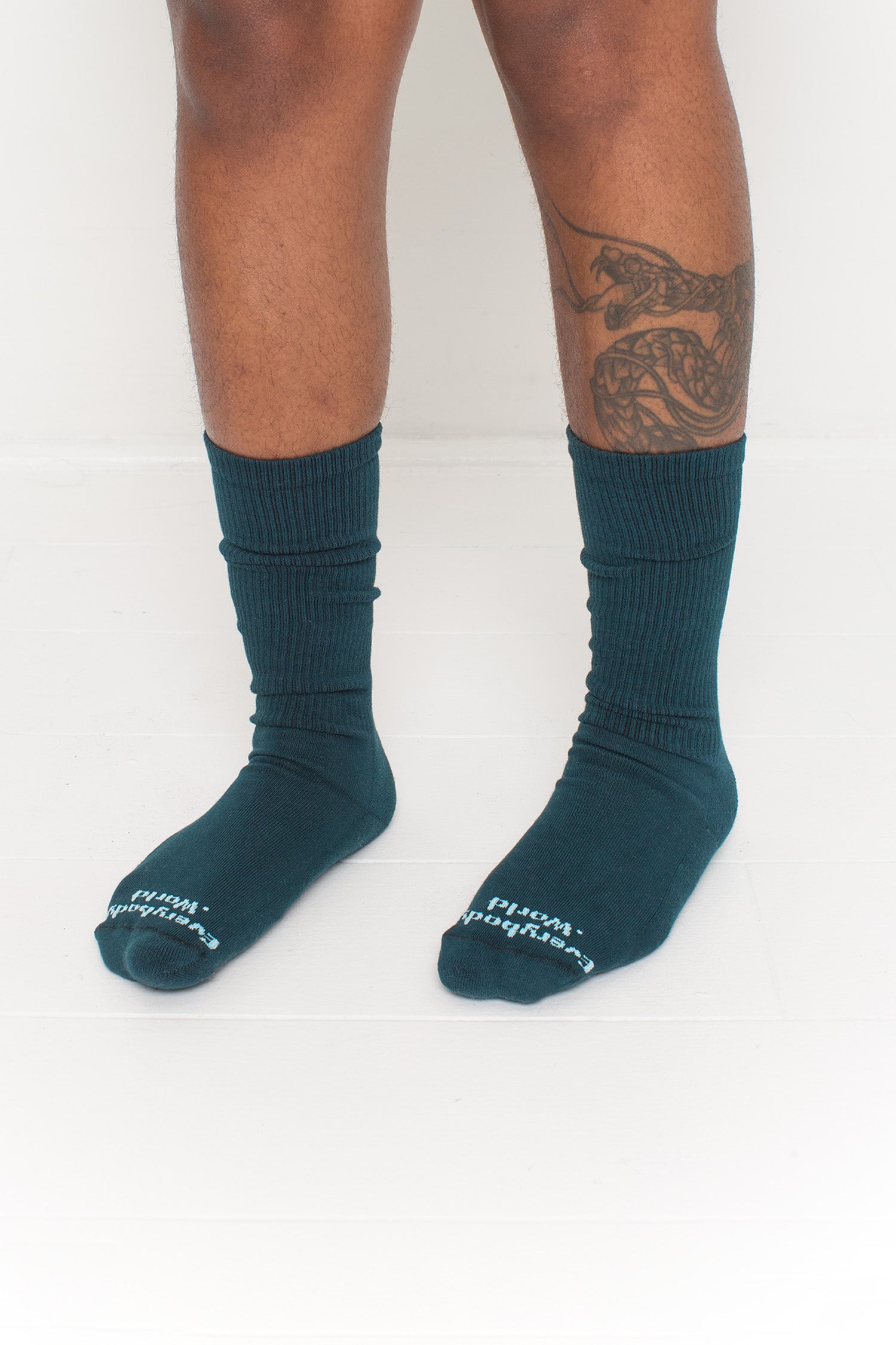 Juniper Squishy Socks, branded 'Everybody.World' in white at the toe, shown on a person's lower legs.