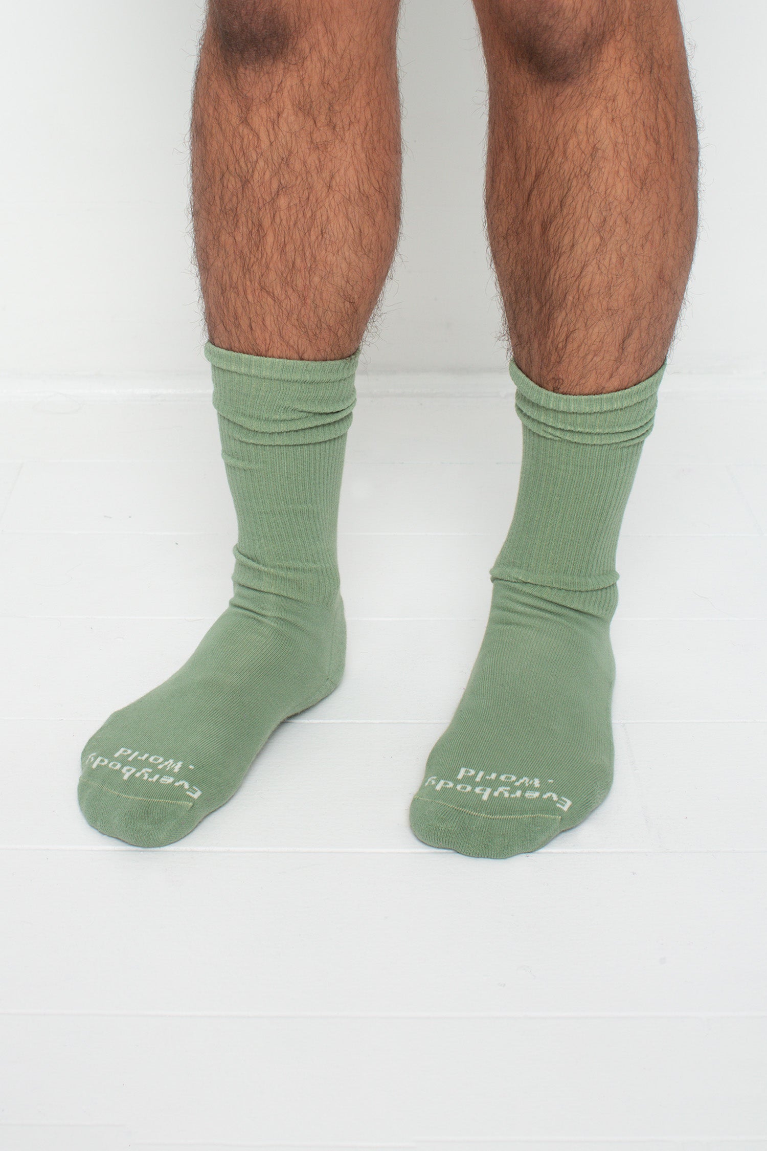 Wasabi Squishy Socks, branded 'Everybody.World' in white at the toe, shown on a person's lower legs.