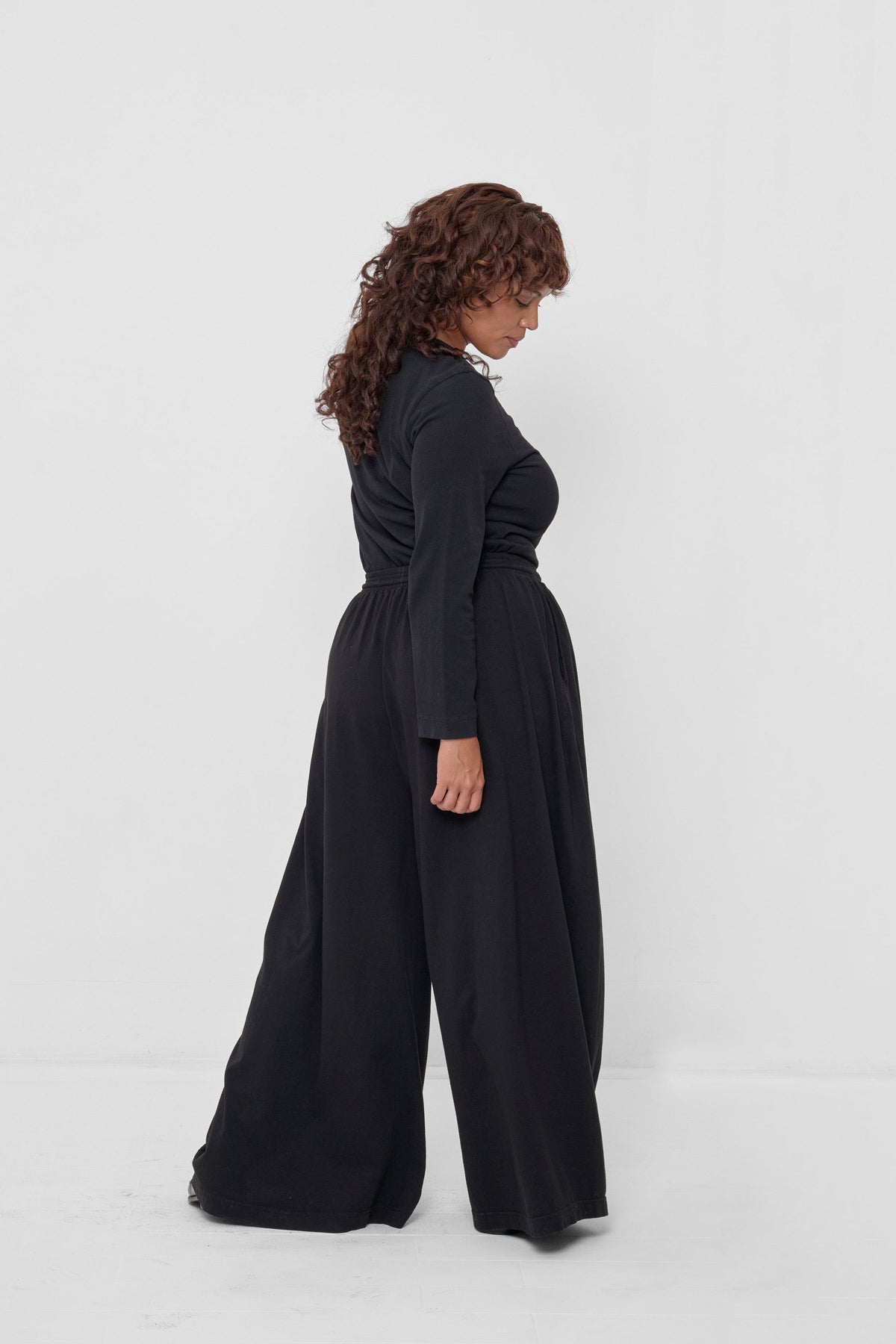 Straight Sleeve Tailored Trash Tee in Black - back fully body view on model, styled with Black Tubular Pants