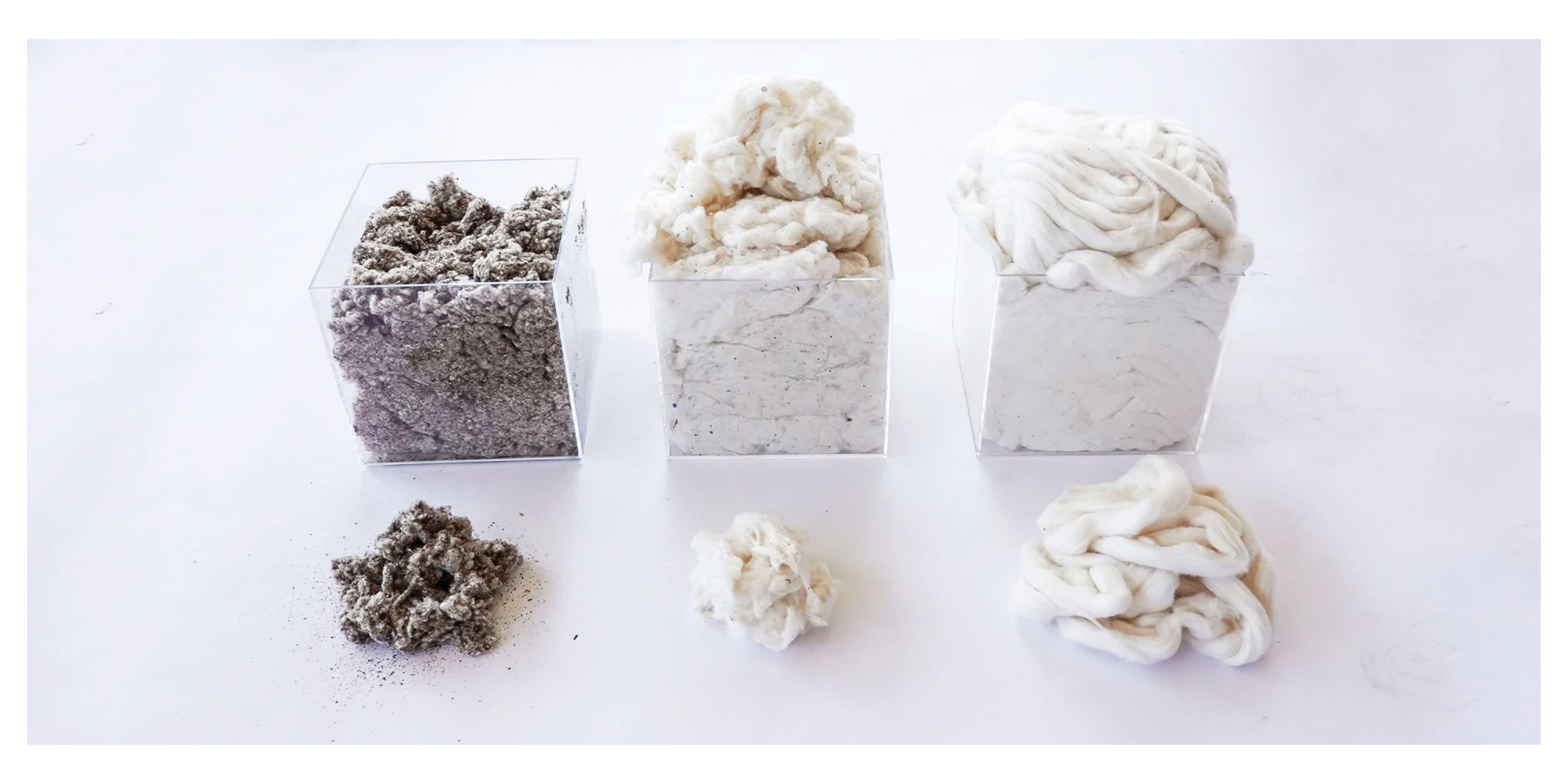 Three transparent containers filled with varying stages of recycled cotton material—gray dust, loose fibers, and compacted cotton—against a white background.