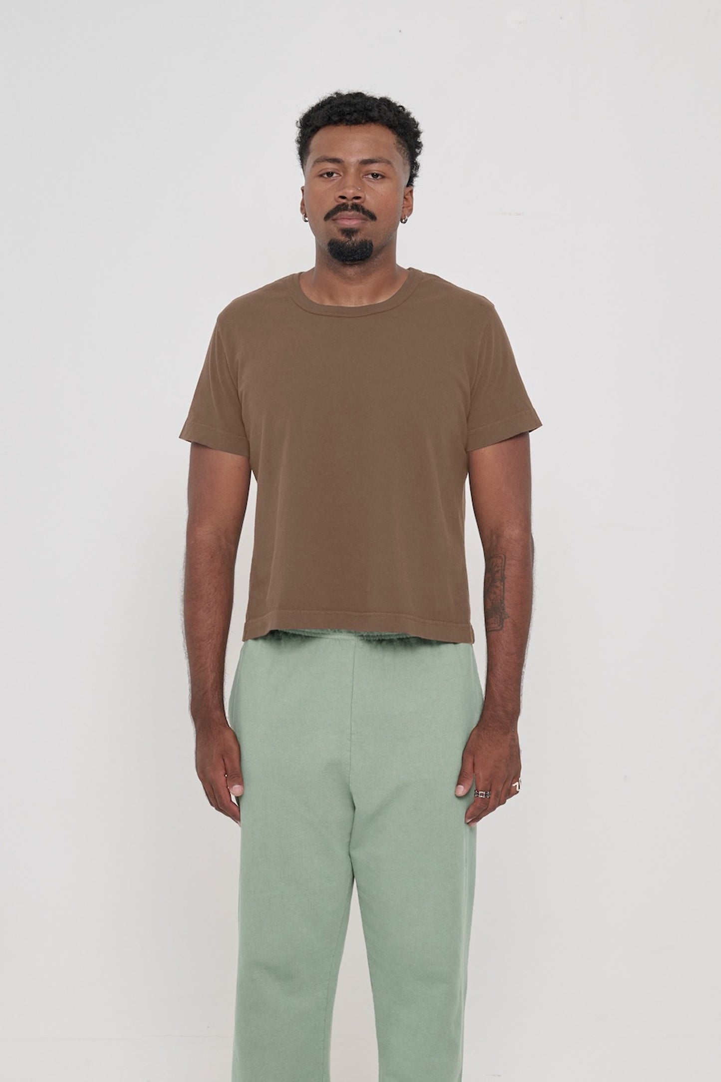 6'2" man wearing a Dry Soil Tailored Trash Tee, shirt hem hits his upper hip. 