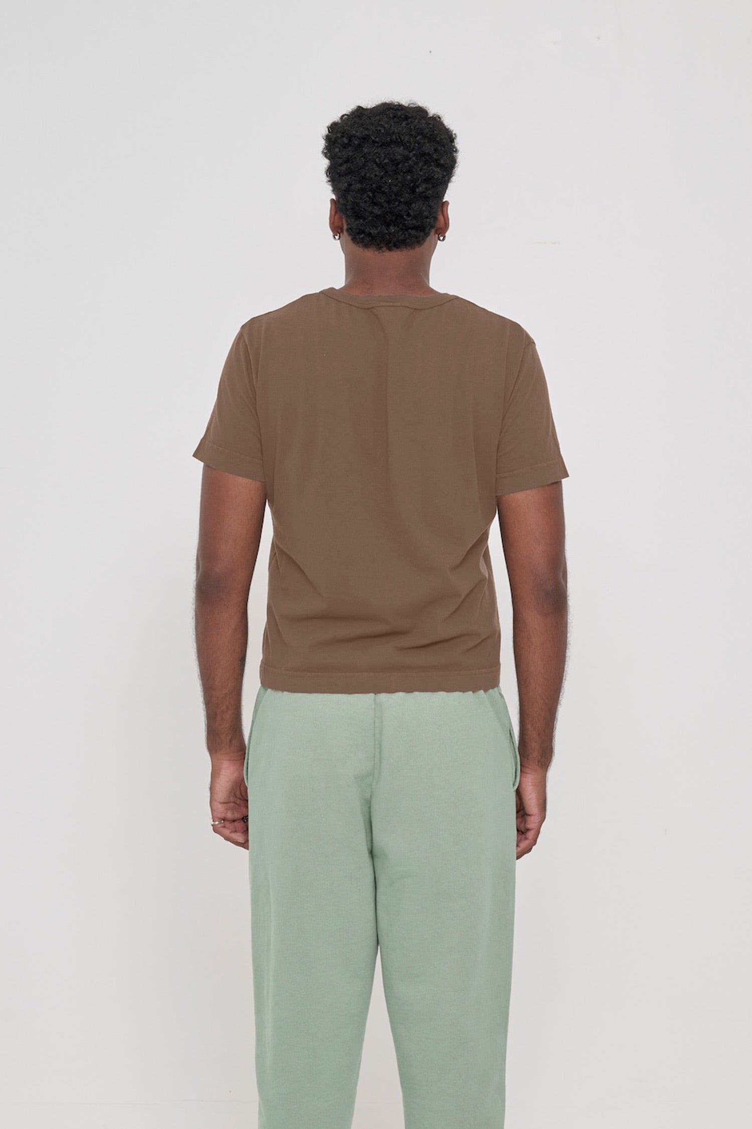 Tailored Trash Tee in Dry Soil, back view on a man, showcasing a relaxed slim fit throughout. 
