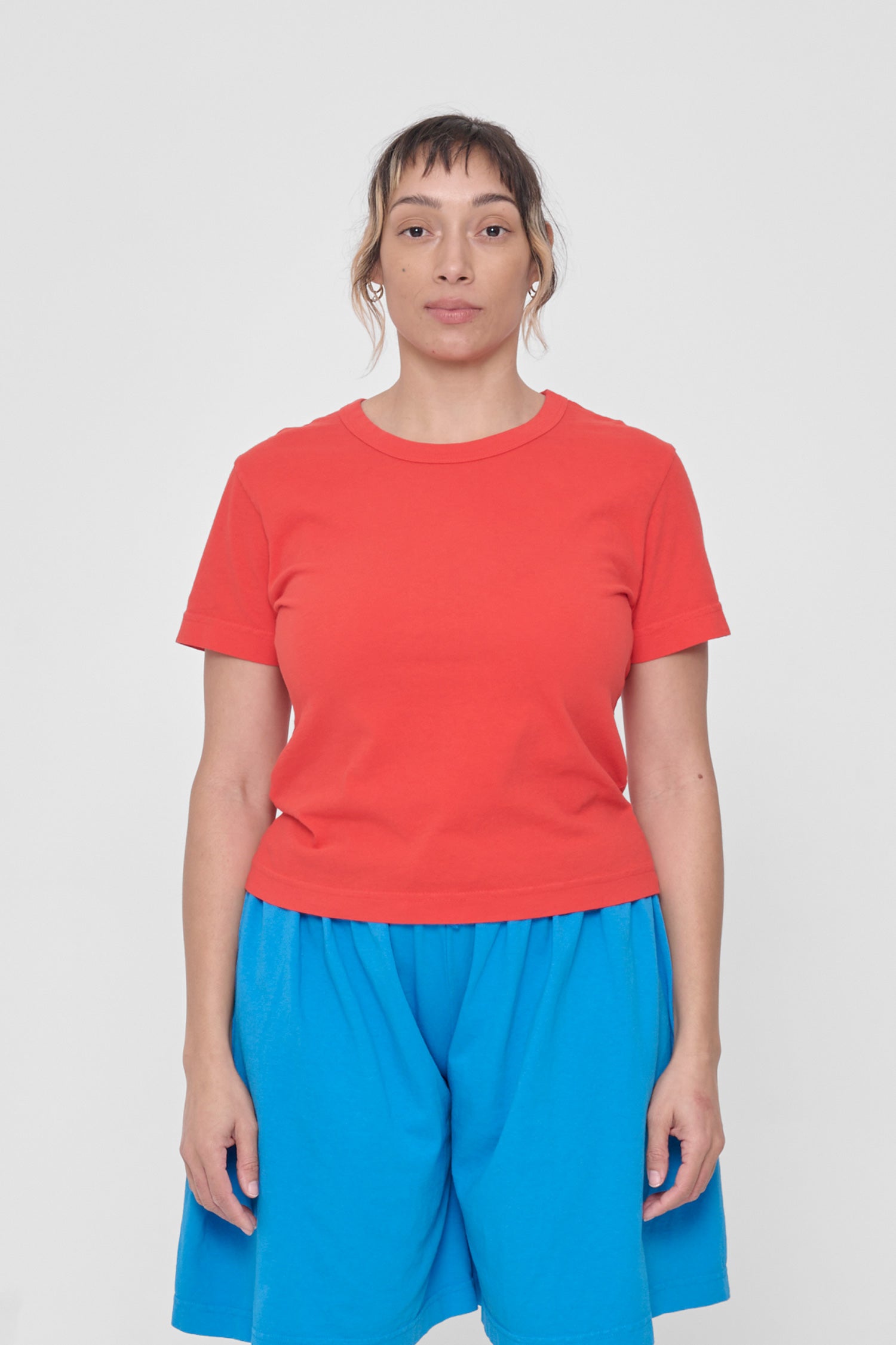 A 5'4" woman in a size M Lava Tailored Trash Tee. Hem ends at her upper hip. 
