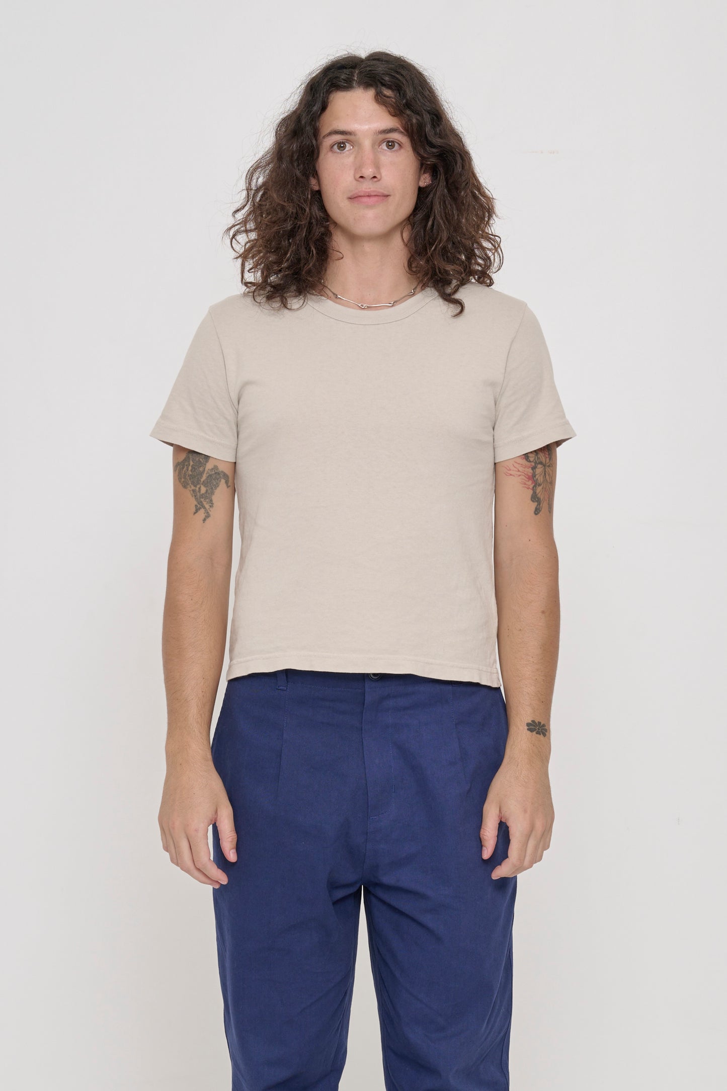 6' person wearing Oat Tailored Trash Tee, shirt hem hits their upper hip. 