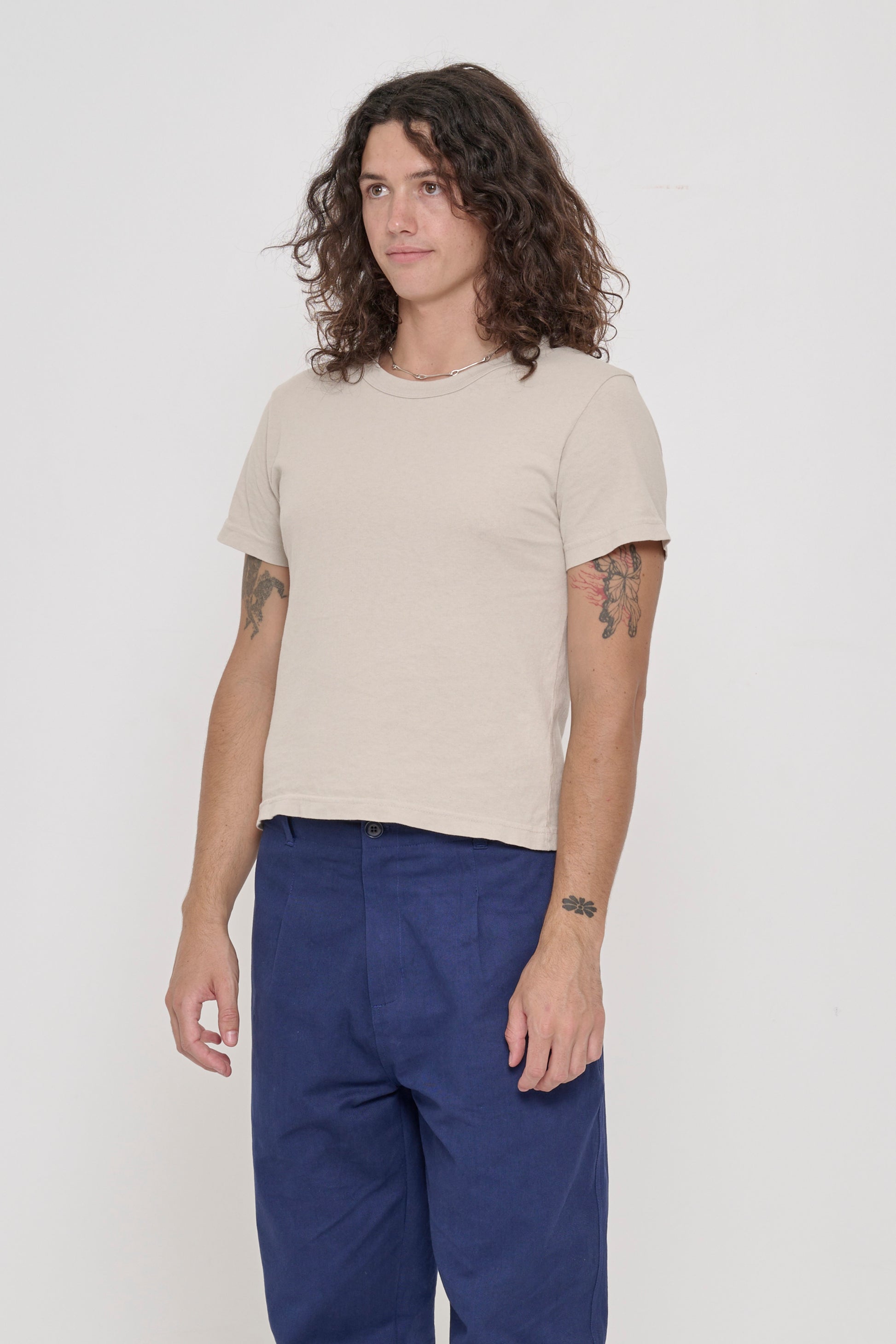 Tailored Trash Tee in Oat - 3/4 front view on person, showing side seams and slim short sleeves.
