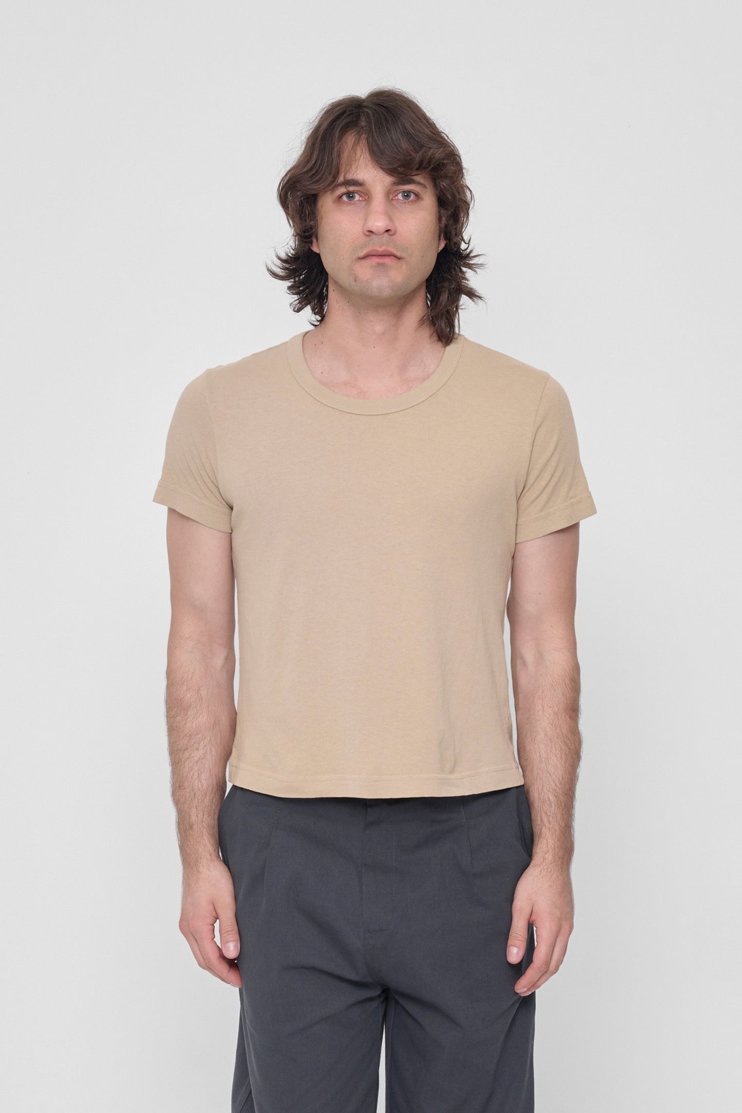 6'2" man in a size L Sand Storm Tailored Trash Tee. Hem hits his upper hip. 