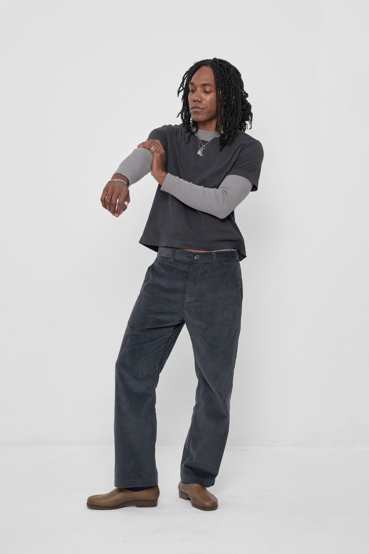 Tailored Trash Tee in Slate – front view on model, tee layered Stone Rib Long Sleeve, Slate Cord Pants and Plasticana Gardana Clogs