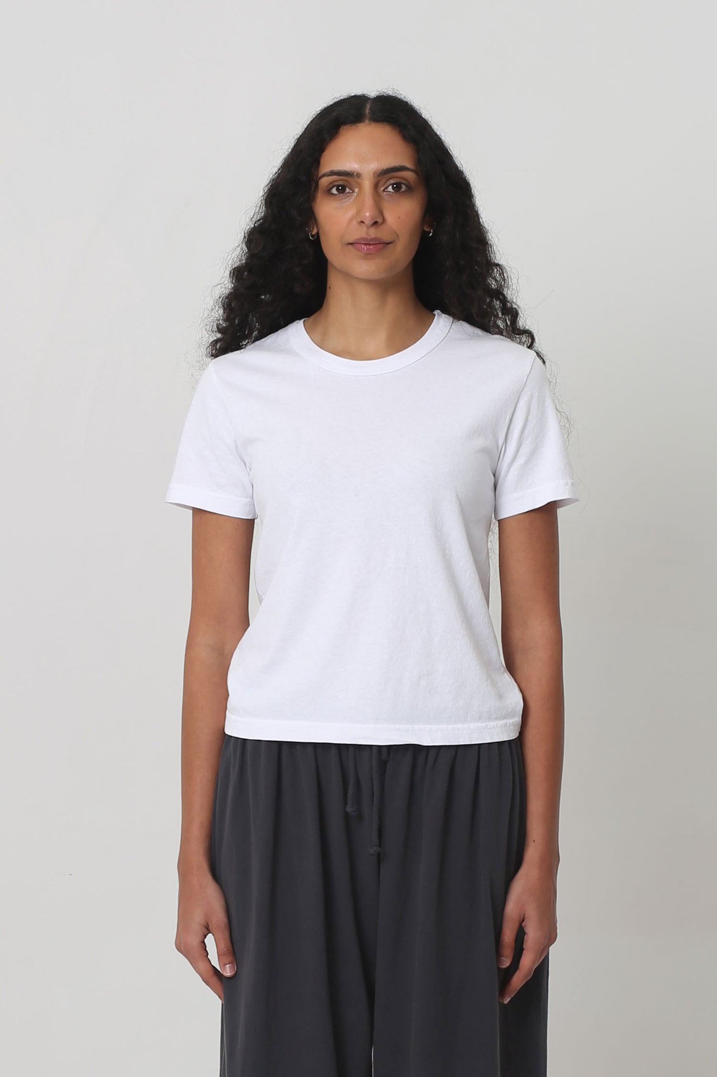5'10" woman in a White Tailored Trash Tee in Size S. Shirt hem ends at her upper hip. 