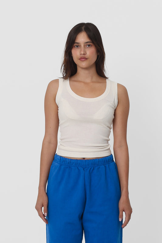 A 5'5" woman wearing a size XS The Tank in Natural. Hem hits her navel.
