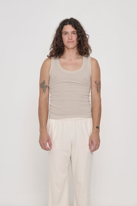Front view of a 6' person wearing The Tank in Oat. Hem hits their high hip.