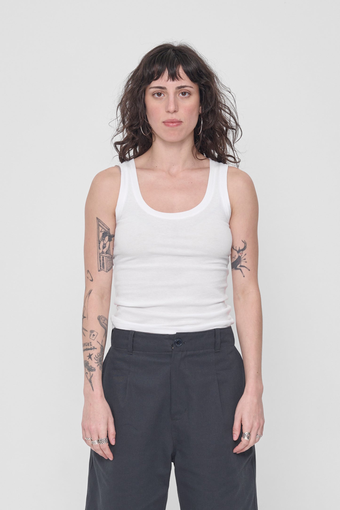 A 5'6" woman wearing a size XS The Tank in White. Hem hits her just below her navel.