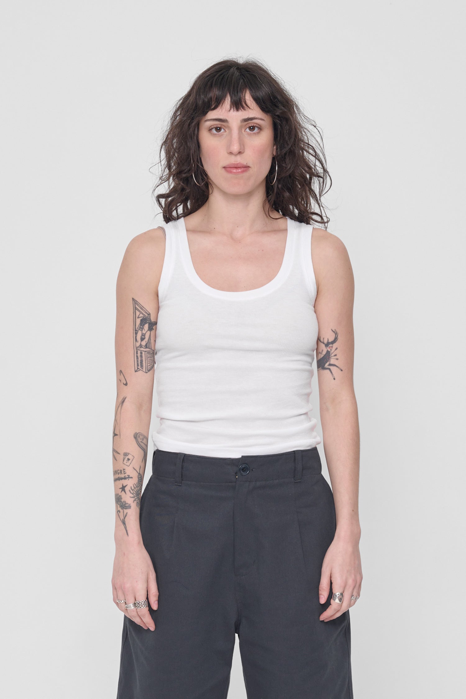 A 5'6" woman wearing a size XS The Tank in White. Hem hits her just below her navel.
