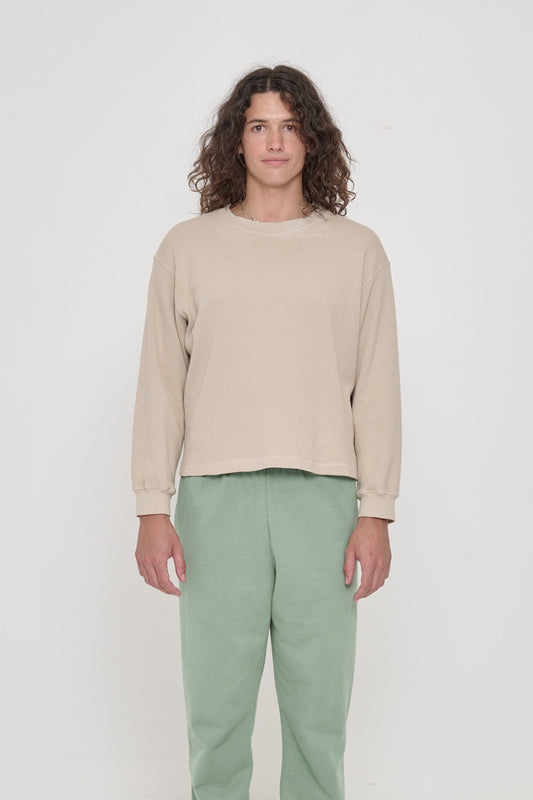 A 6'0" person wearing Oat Thermal Long Sleeve Boxier Trash Tee in size M. Shirt hem hits the top of the hip. 