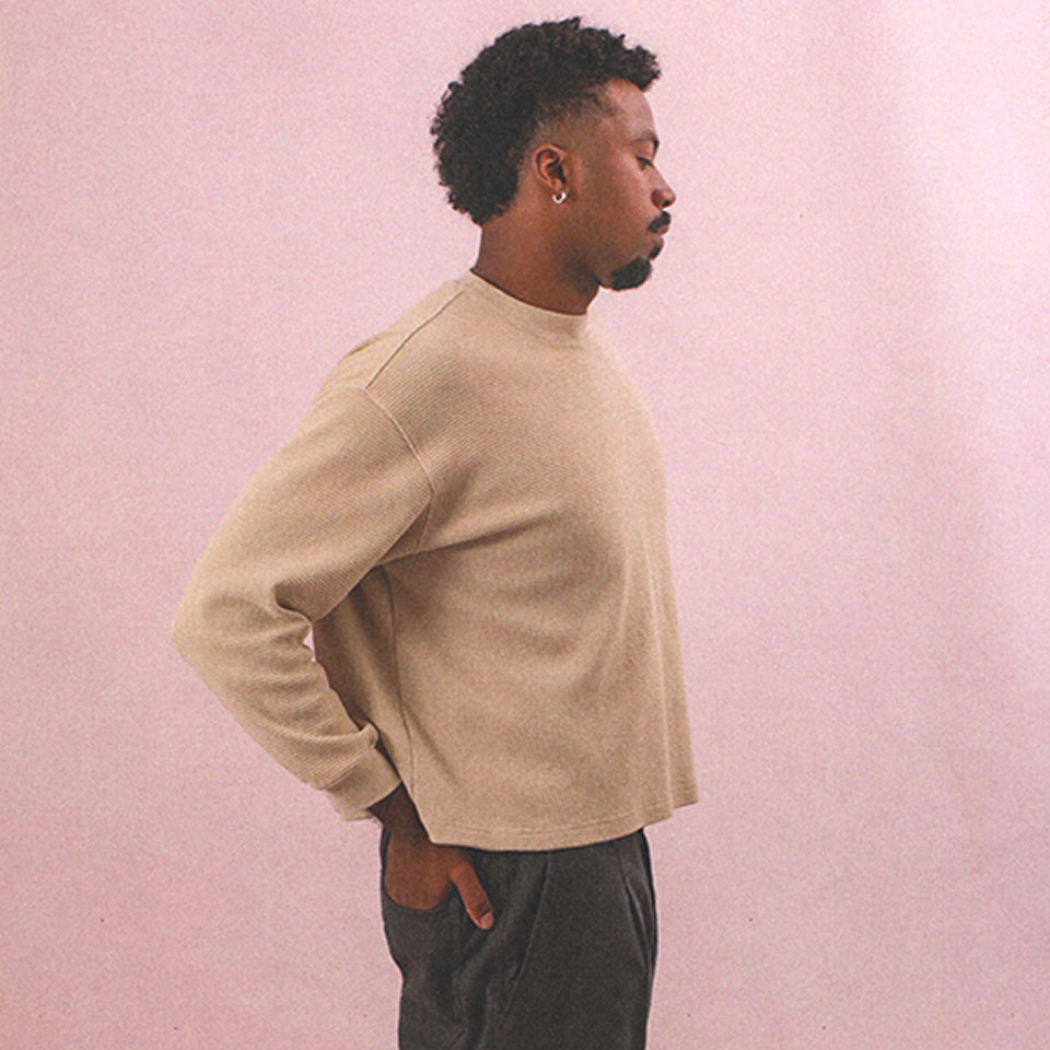 Man with hand in back pocket wearing a Thermal Long Sleeve Boxier Trash Tee in Oat and Cotton Twill Life Uniform Pants in Slate.