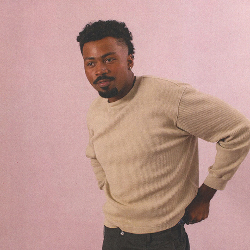 Man wearing an Oat Thermal Long Sleeve Boxier Trash Tee against a pink background.