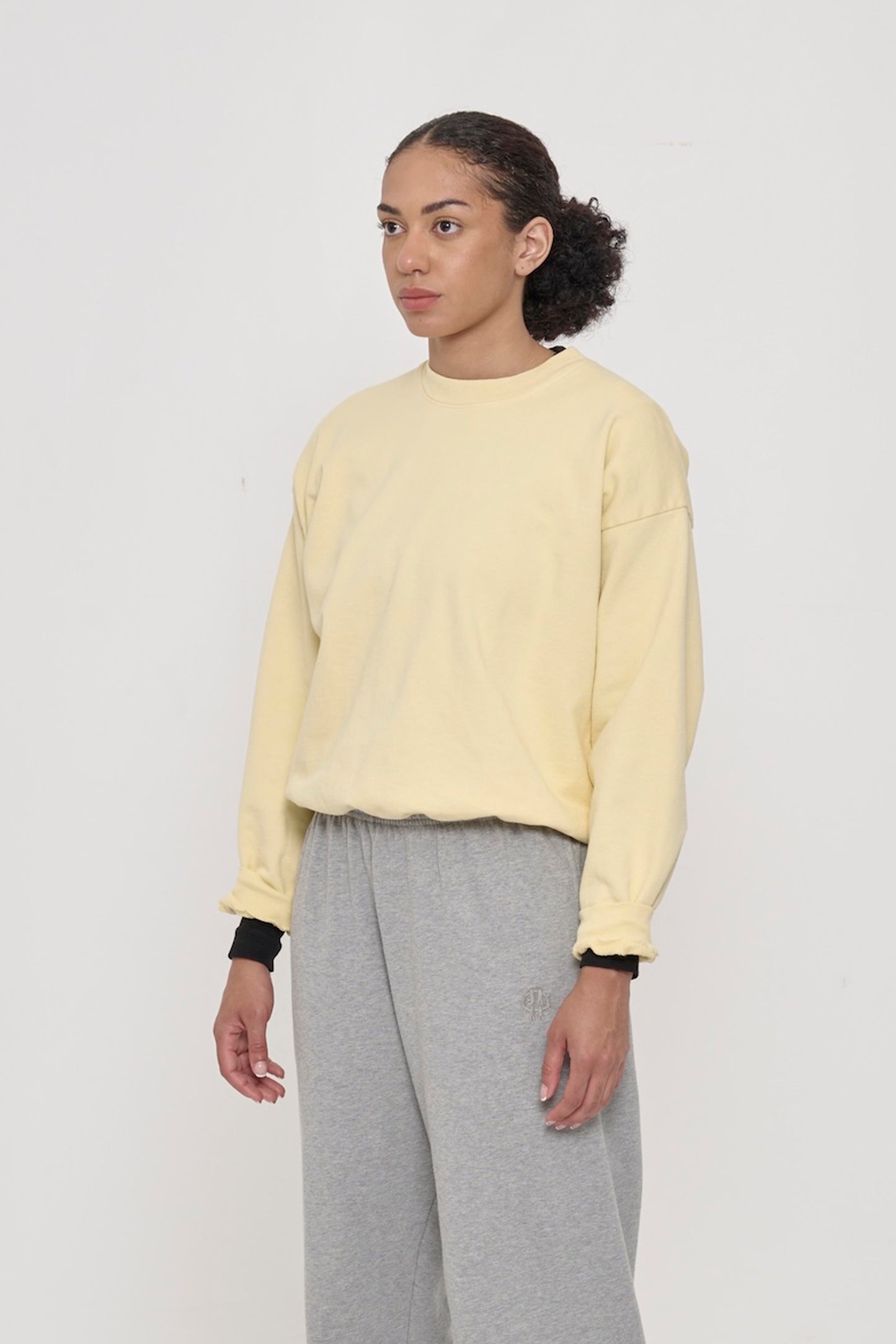3/4 front view of person wearing a French Butter Trash Crewneck, showcasing sleeve's relaxed fit and drop shoulder.