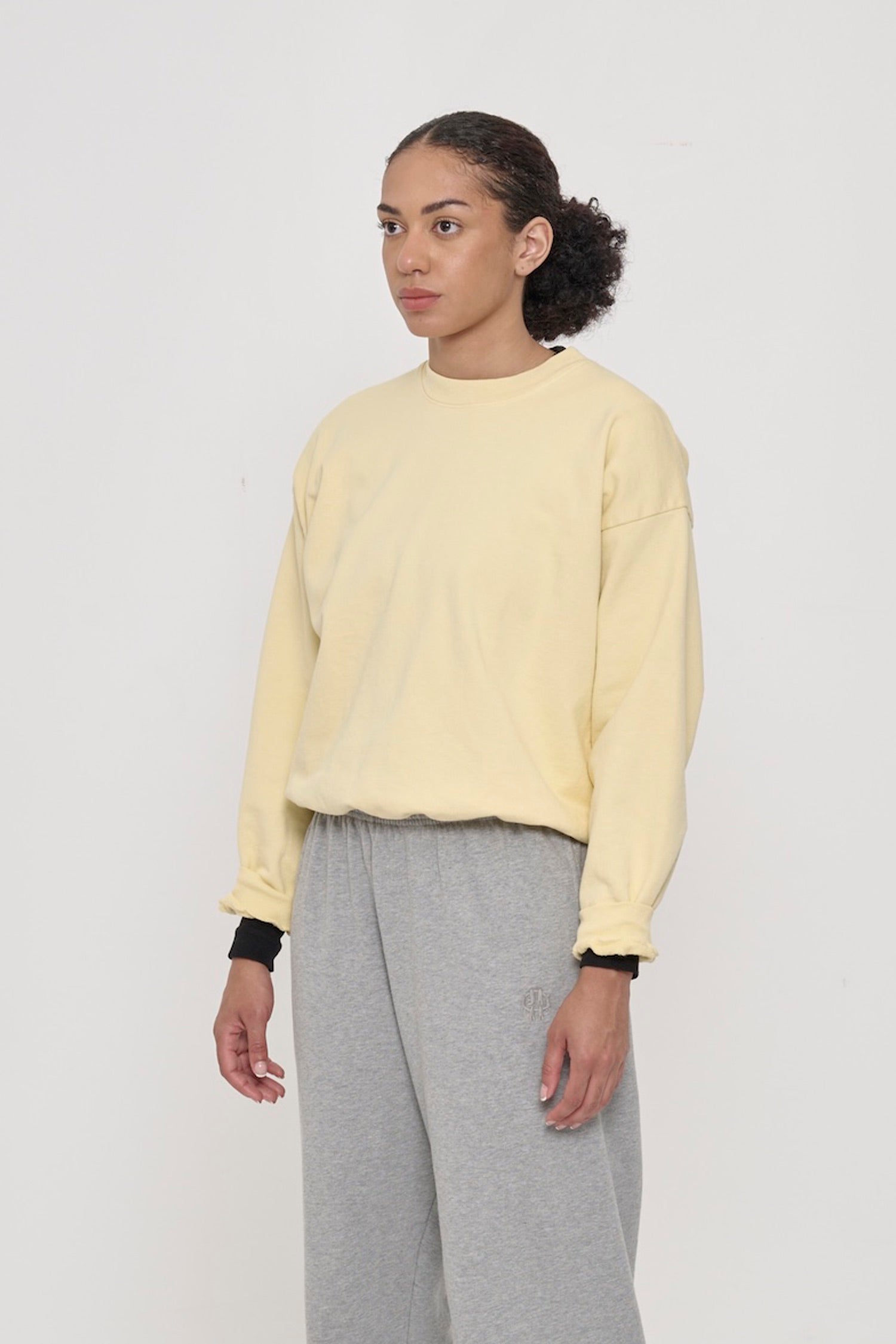 3/4 front view of person wearing a French Butter Trash Crewneck, showcasing sleeve's relaxed fit and drop shoulder.