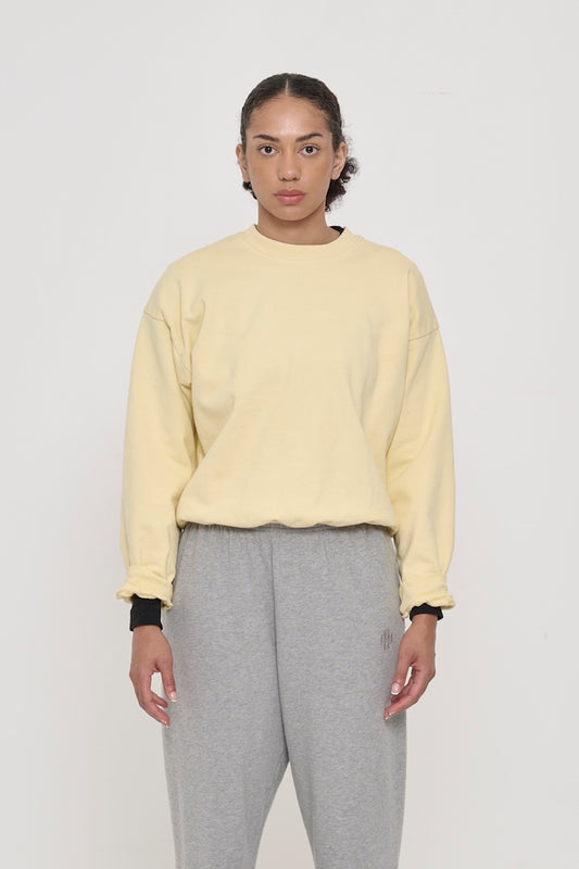 Front view of a person wearing French Butter Trash Crewneck. Hem hits their upper hip.