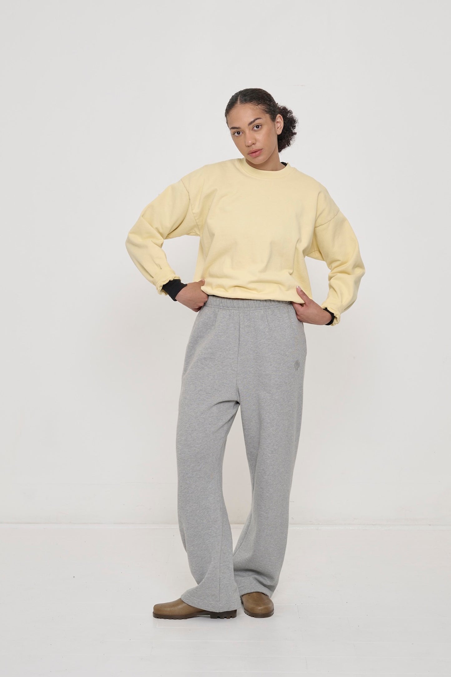 Woman wearing French Butter Trash Crewneck and Heather Sweatpants with Black Rib Long Sleeve under.
