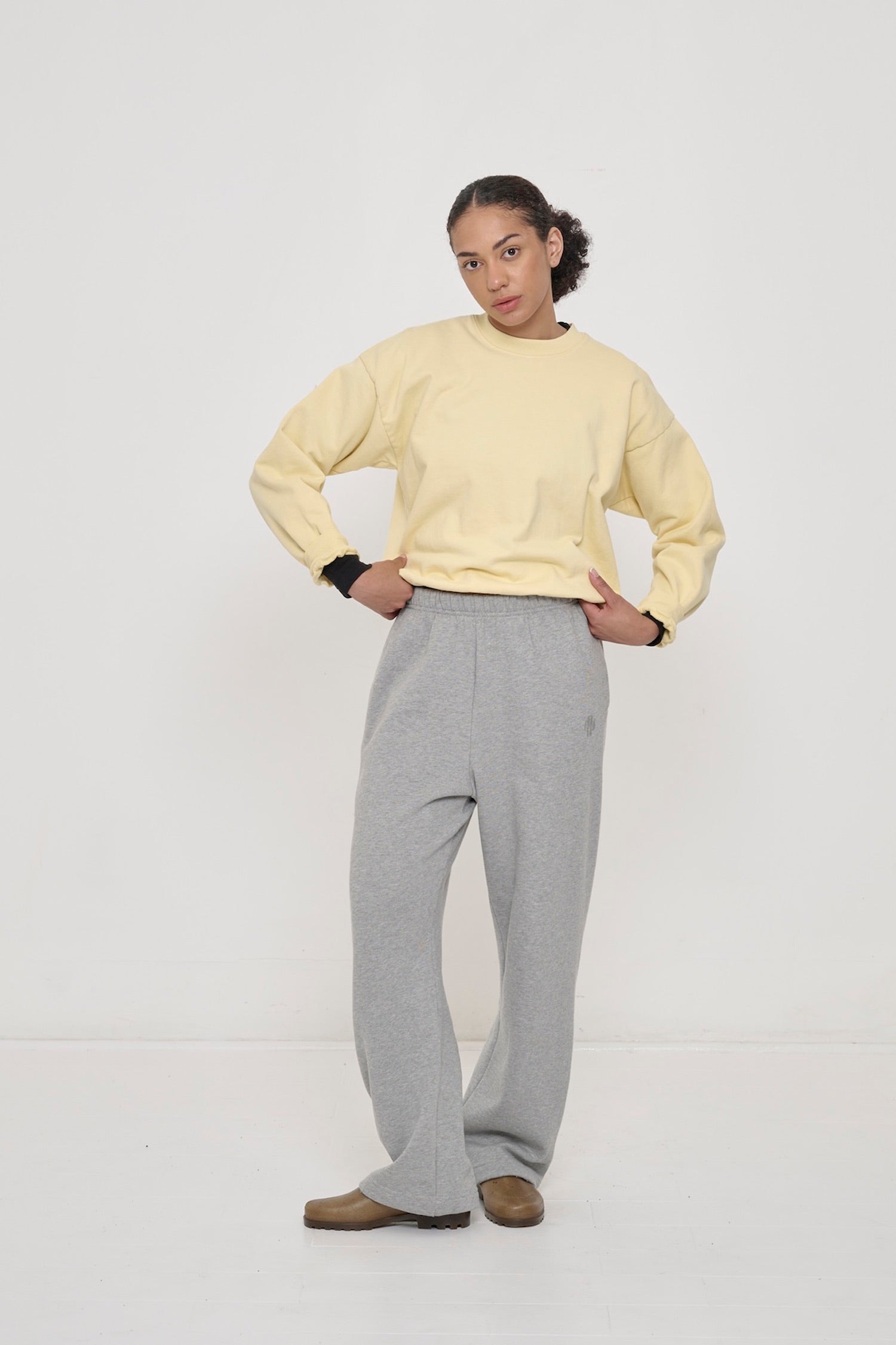 Woman wearing French Butter Trash Crewneck and Heather Sweatpants with Black Rib Long Sleeve under.