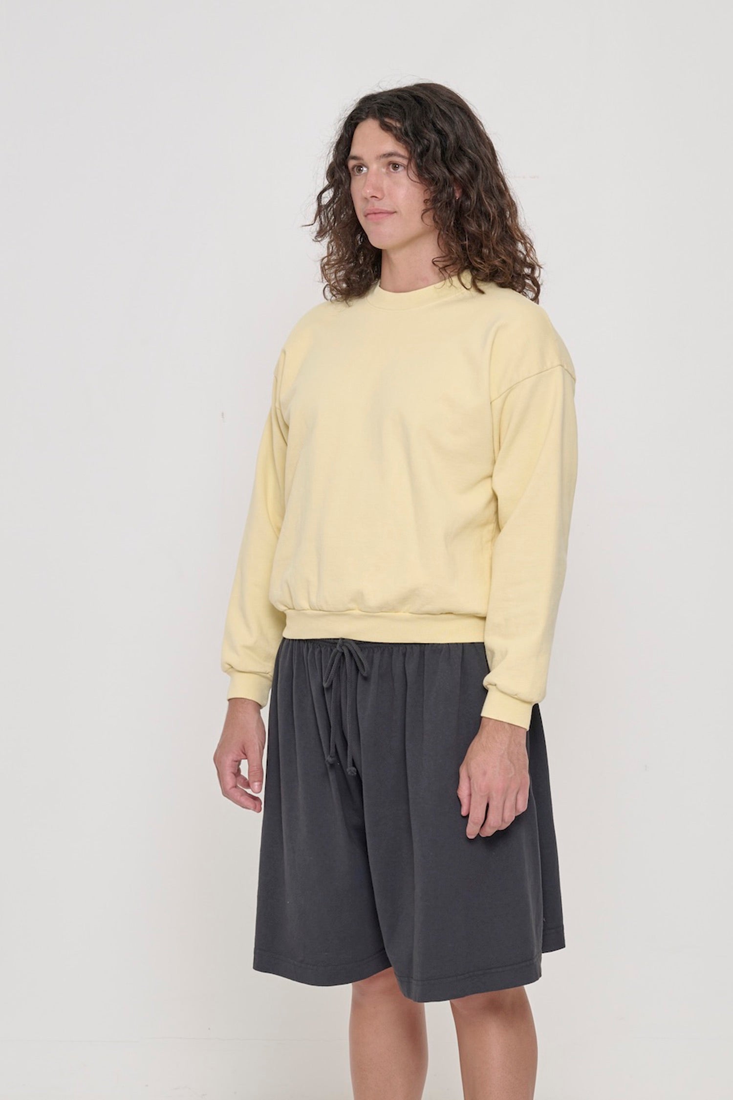3/4 front view of person wearing a French Butter Trash Crewneck, showcasing sleeve's relaxed fit and drop shoulder.