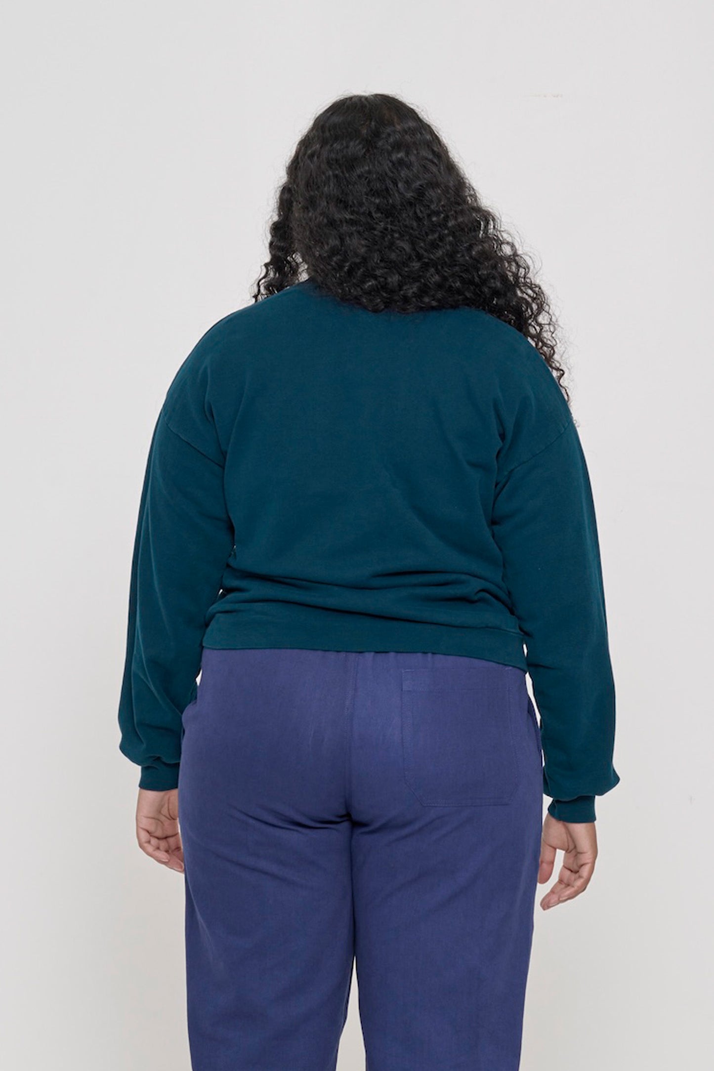 Back view on a person in Juniper Trash Crewneck, relaxed throughout until the rib hem and cuffs.