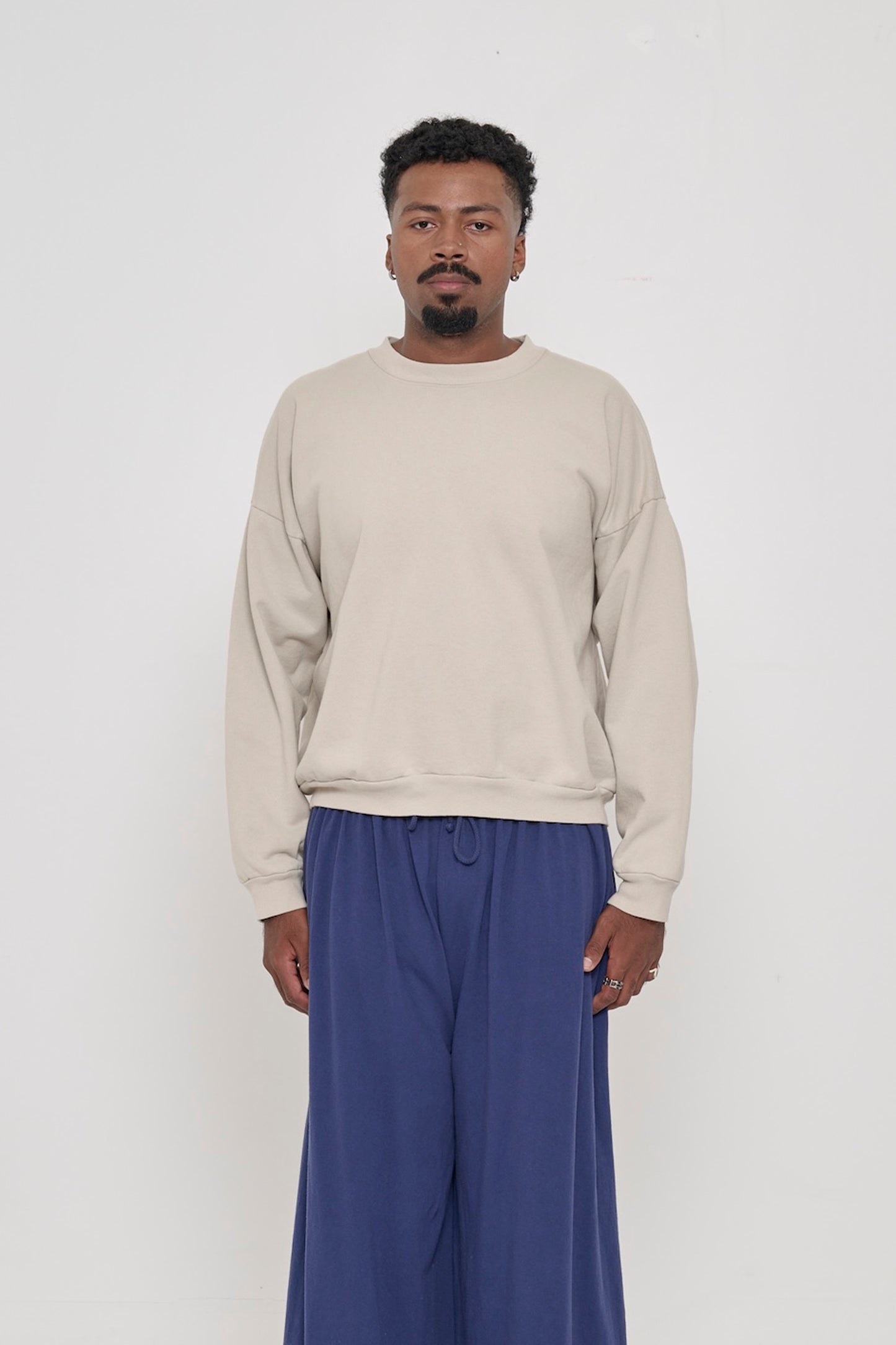 Front view of a person wearing Oat Trash Crewneck. Hem hits their upper middle hip.