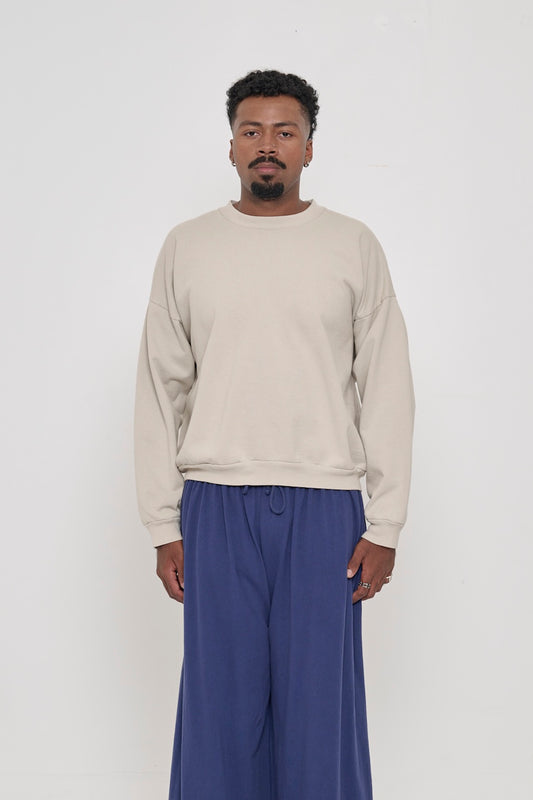 Front view of a person wearing Oat Trash Crewneck. Hem hits their upper middle hip.