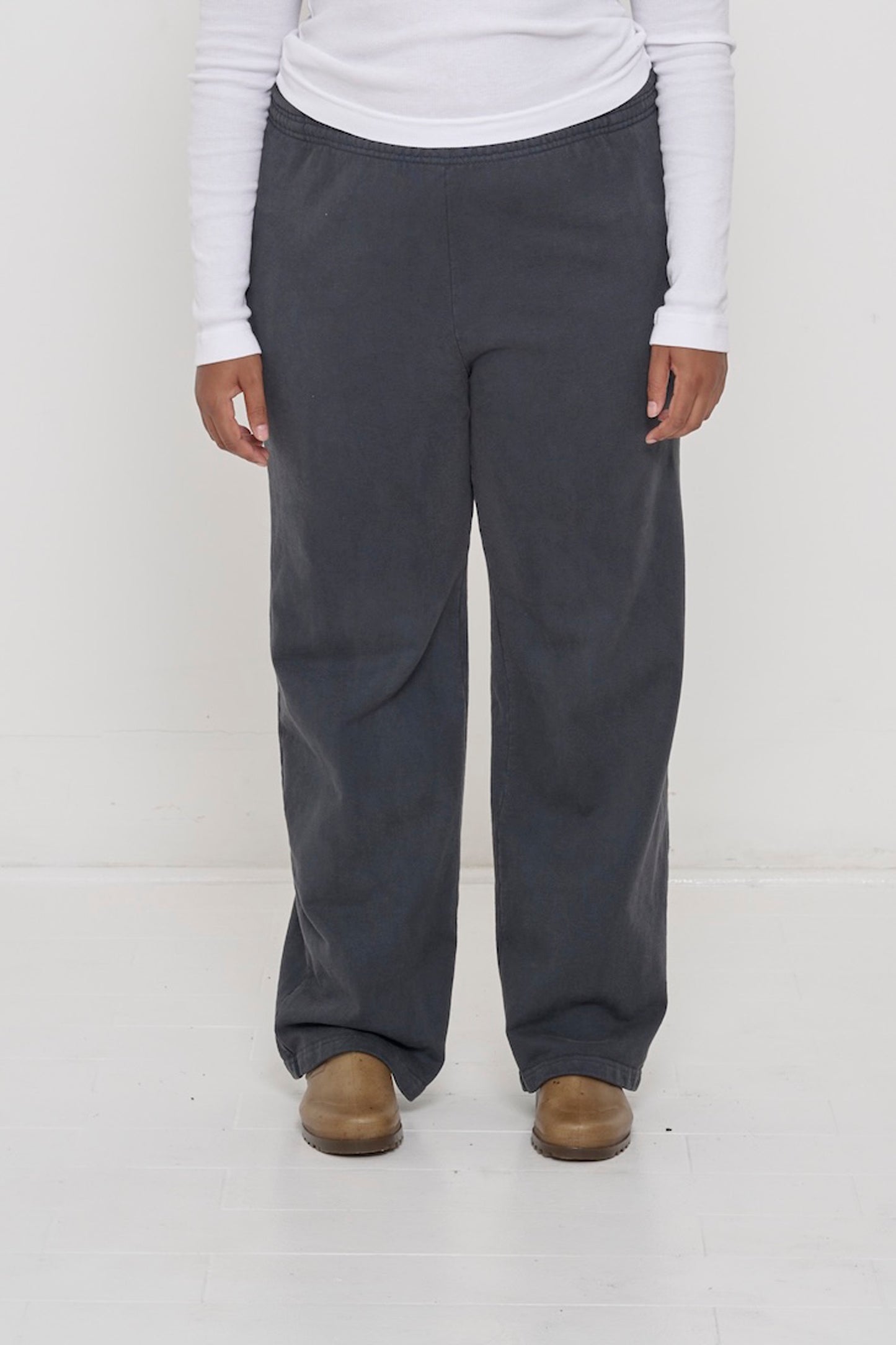 Close-up front view of a person wearing Trash Fleece Apartment Pants in Slate, showing elastic waistband and relaxed drape.
