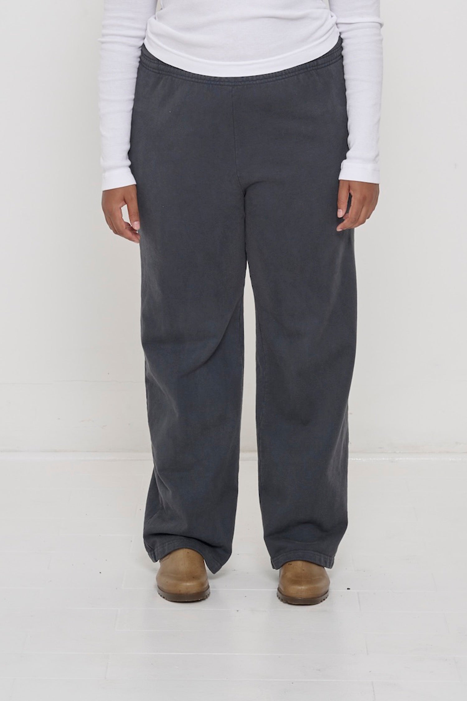 Close-up front view of a person wearing Trash Fleece Apartment Pants in Slate, showing elastic waistband and relaxed drape.
