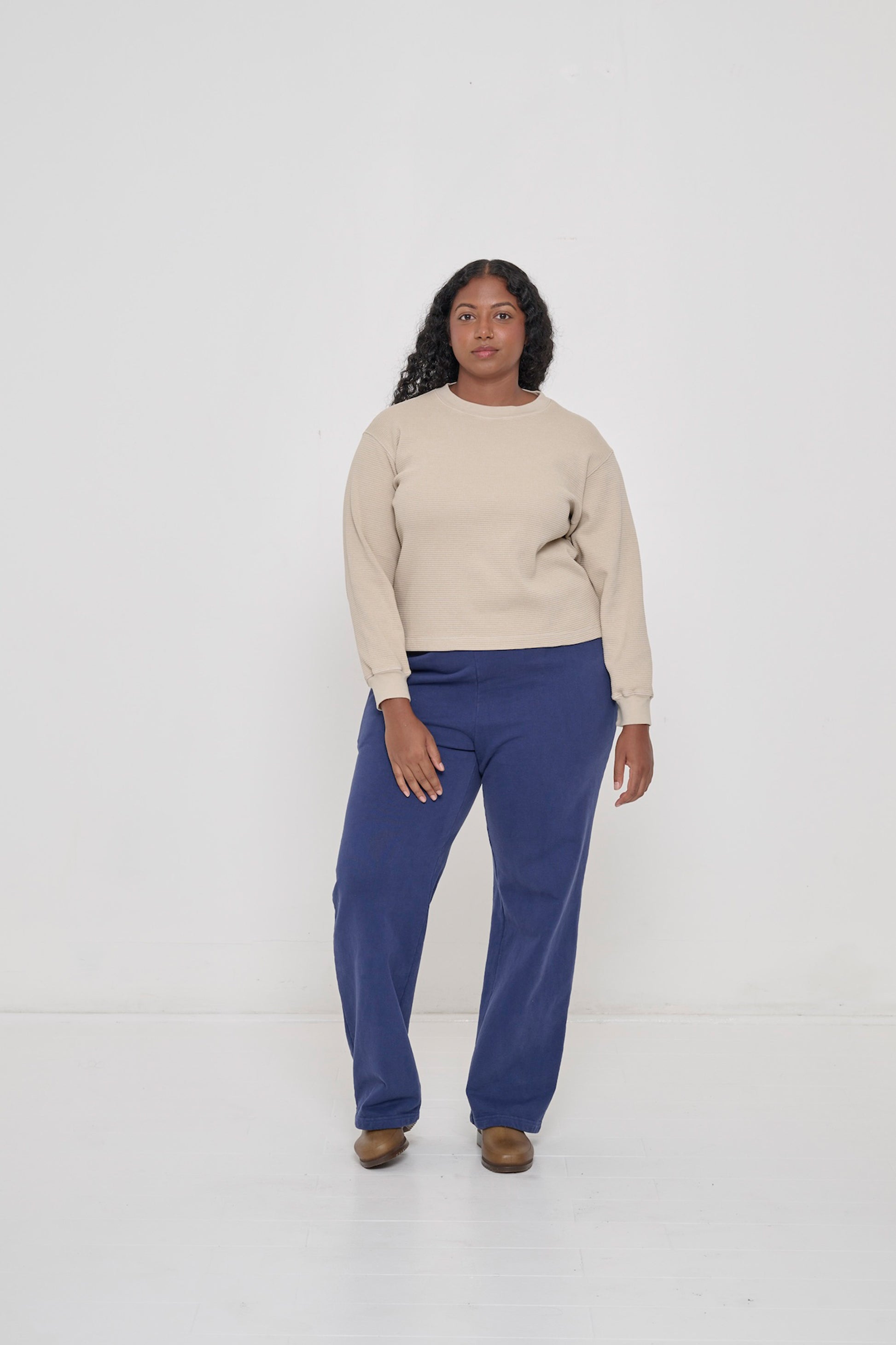 A person wearing Trash Fleece Apartment Pants in Washed navy and Thermal Long Sleeve Boxier Trash Tee in Oat.