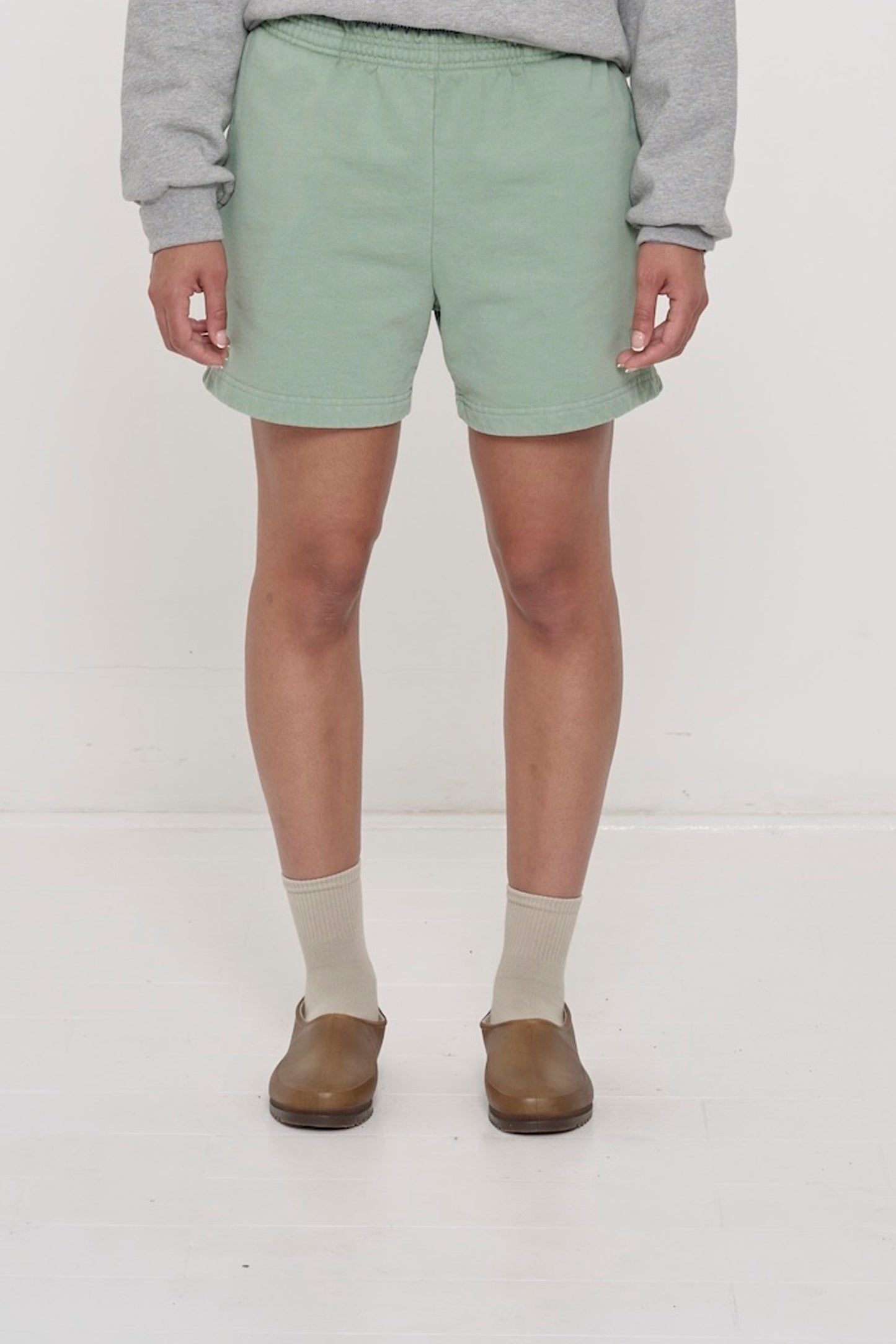 Waist down of a 5'8" person in Size M Wasabi light green Trash Fleece Everyday Shorts. Hem at mid thigh.