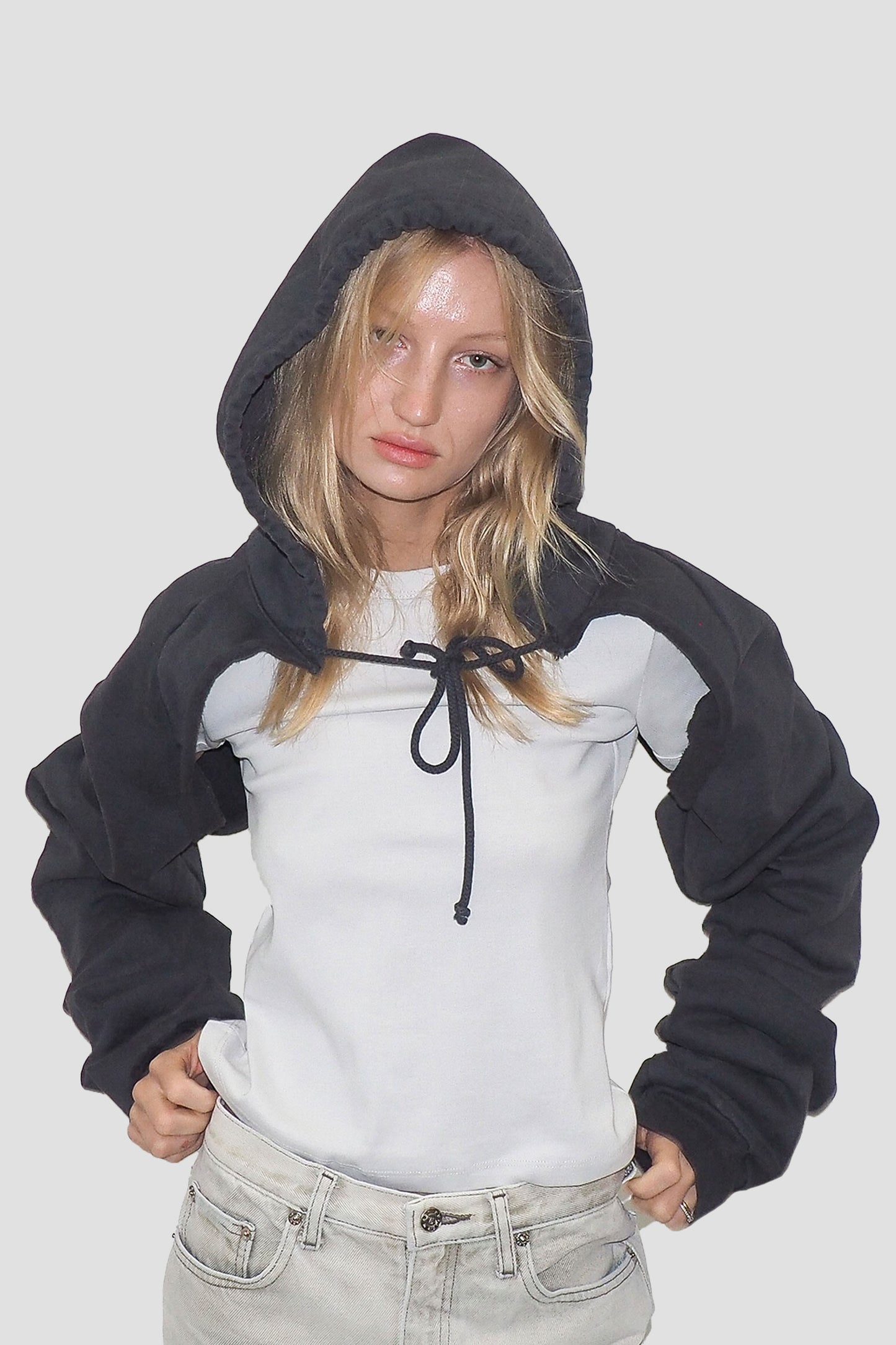 Person wearing a Slate Clyde x Everybody.World Hoodie Scarf over a white T-shirt.