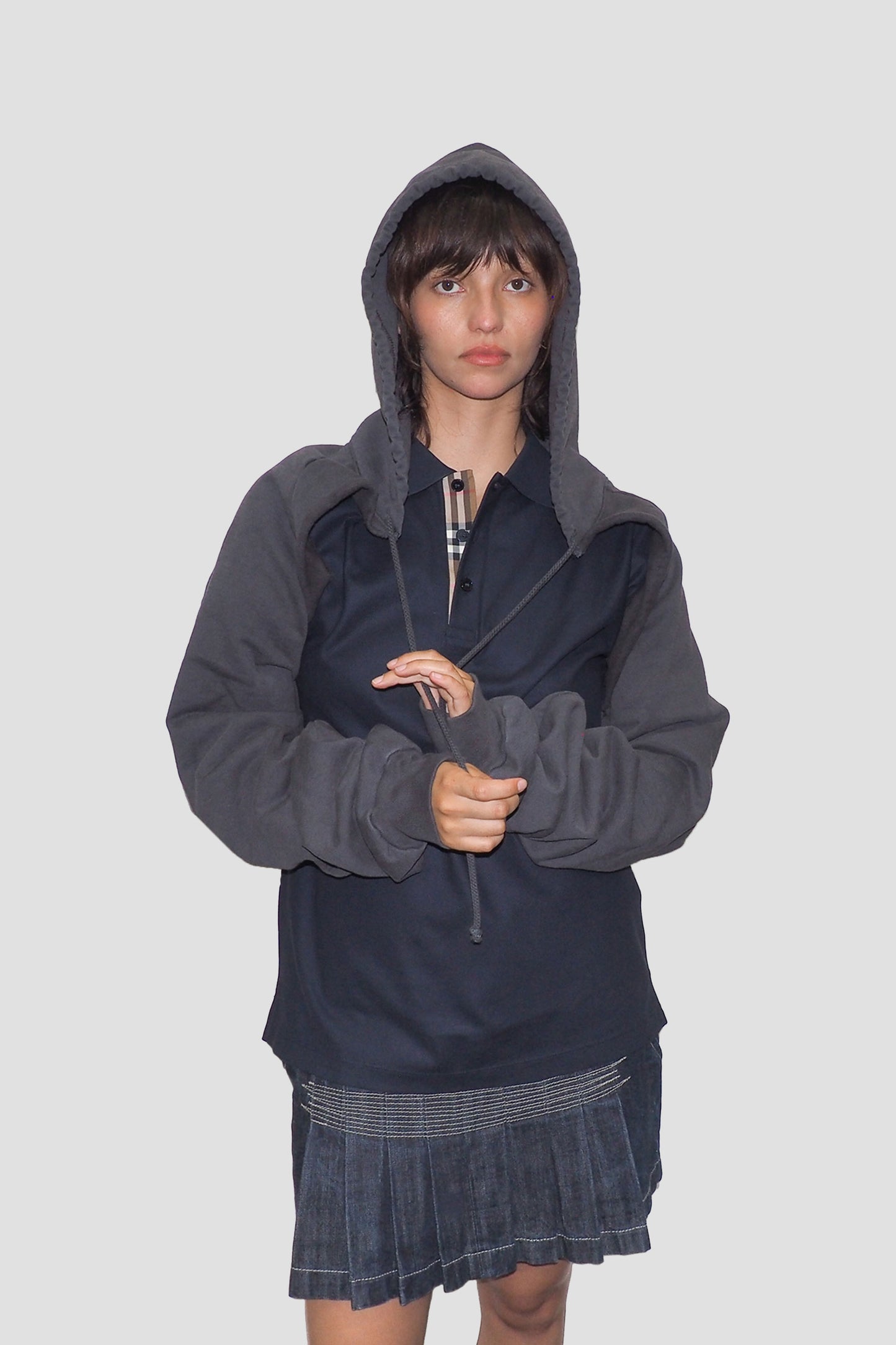 Front view: hood on and model is holding the untied drawcords.