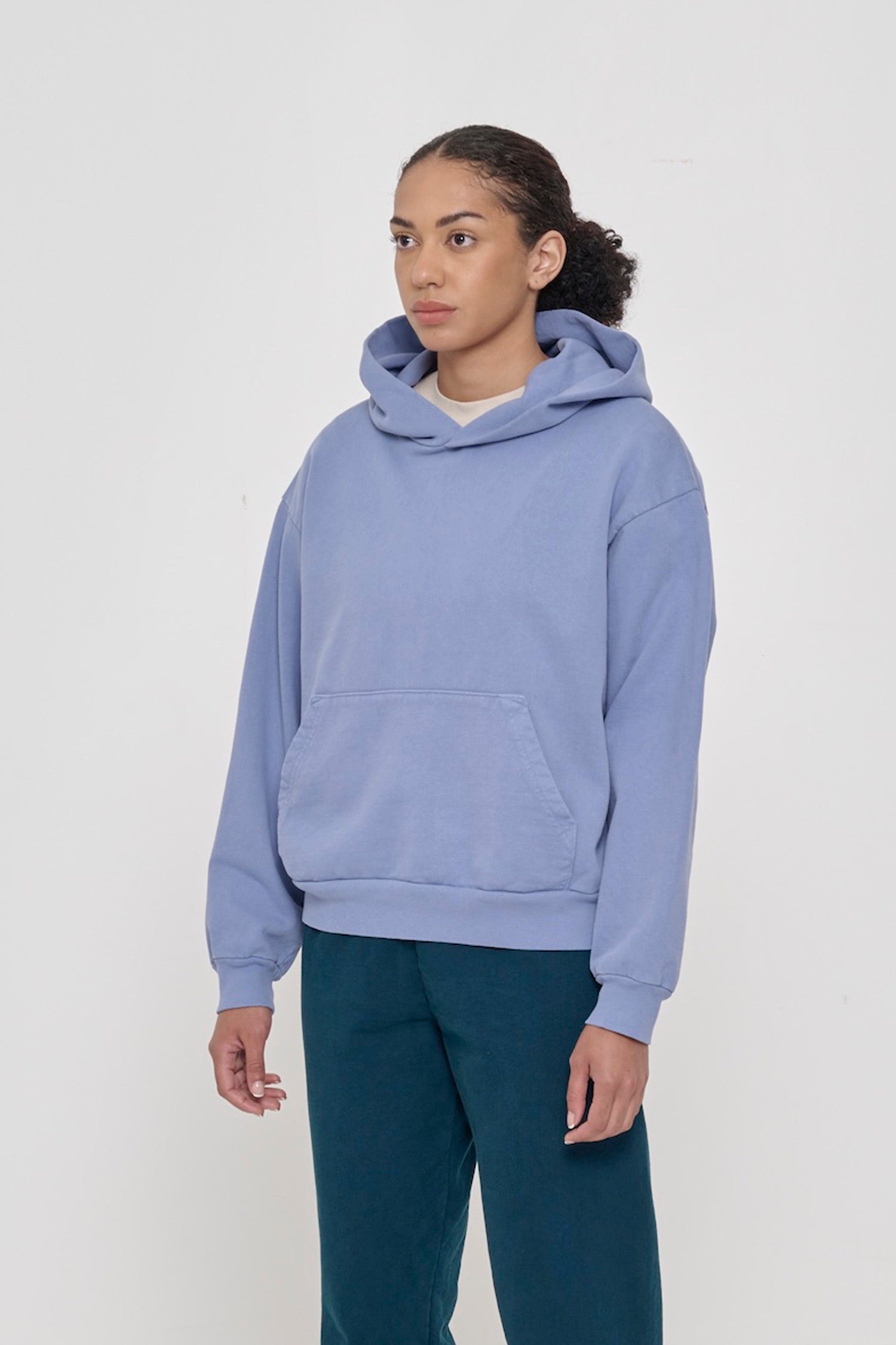 3/4 front view of a woman wearing a Periwinkle Trash Hoodie, showcasing sleeve's relaxed fit and drop shoulder.