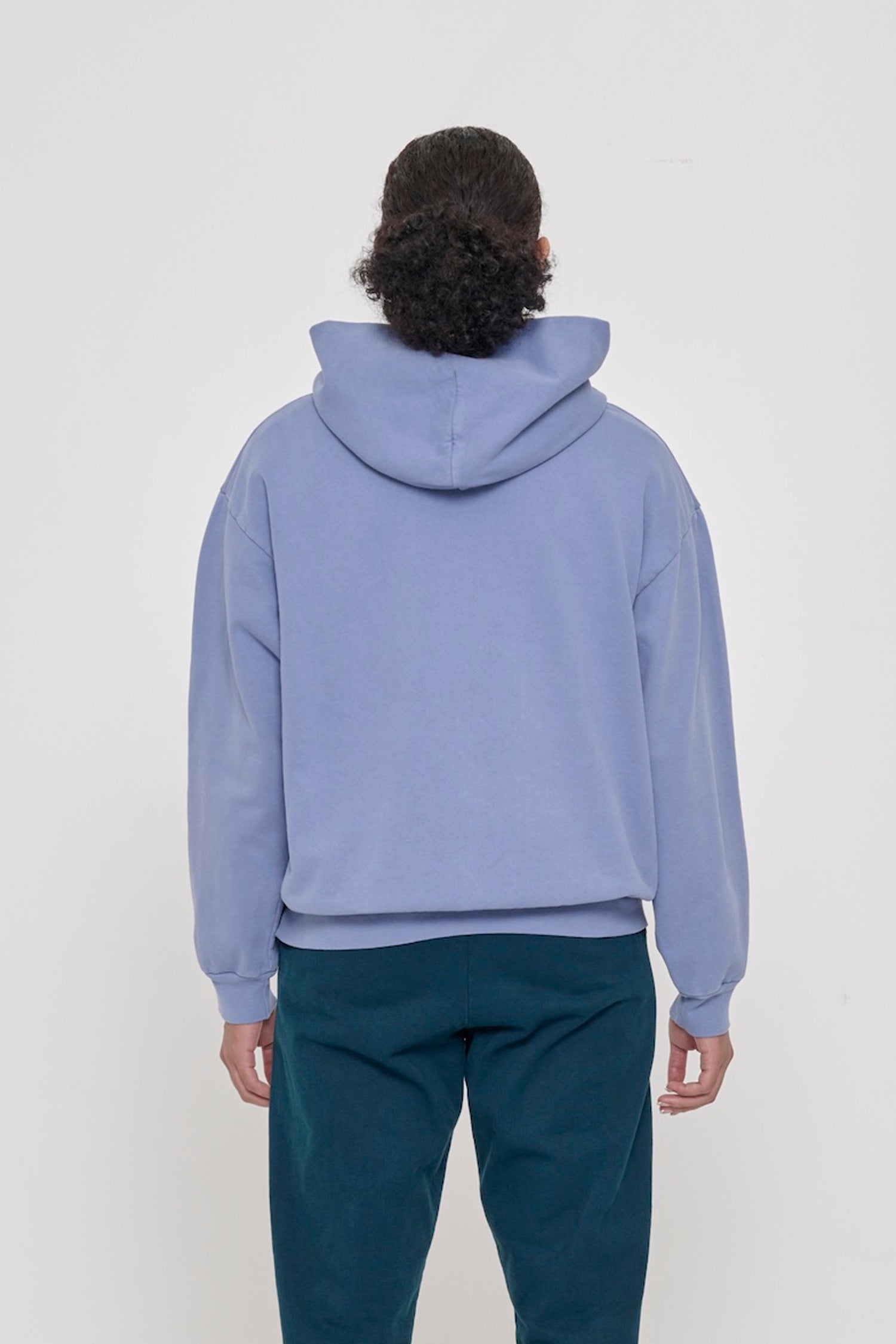 Back view of a woman wearing a Periwinkle Trash Hoodie, highlighting the hood.