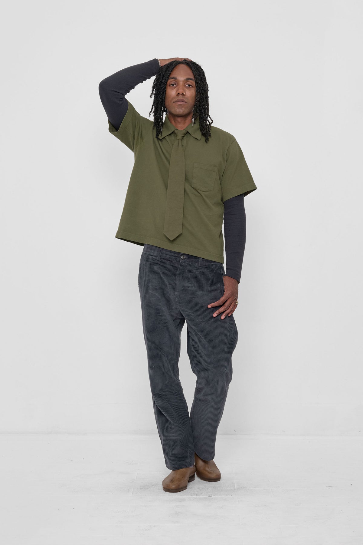 Trash Polo in Olive - front full body view on model, styled with Olive Trash Tie, Slate Rib Long Sleeve, Slate Cord Pants, and Plasticana Gardana Clogs.