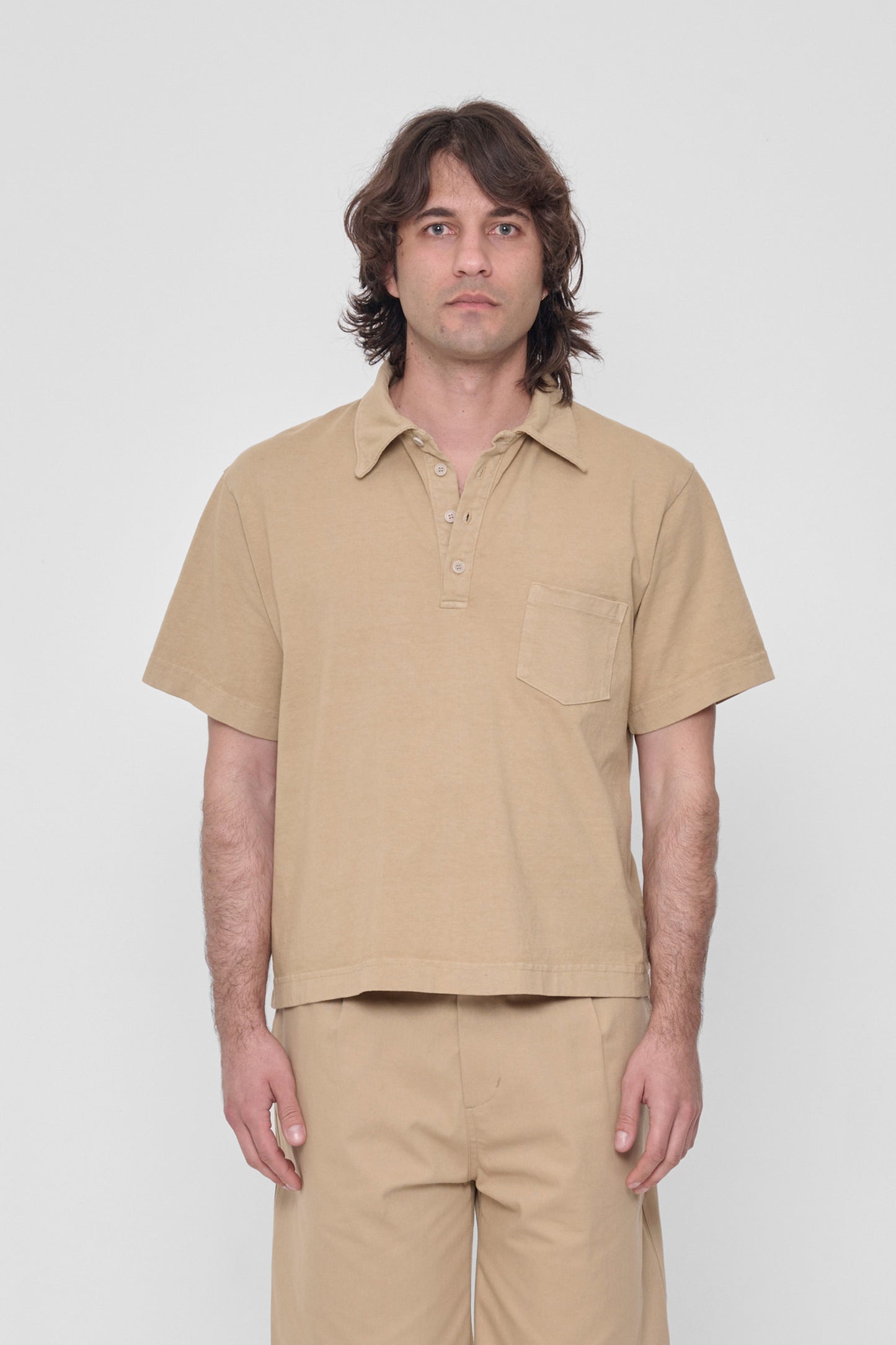 A 6'2" man in a size L Sand Storm Trash Polo. Hem ends at his middle hip.