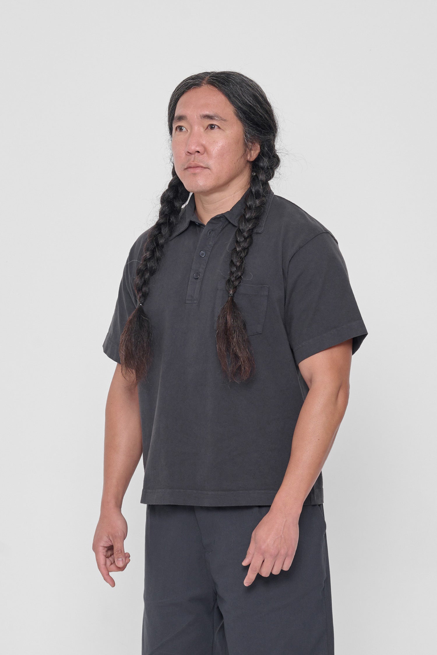 Man turned 45 degrees, featuring short sleeves and left chest pocket.