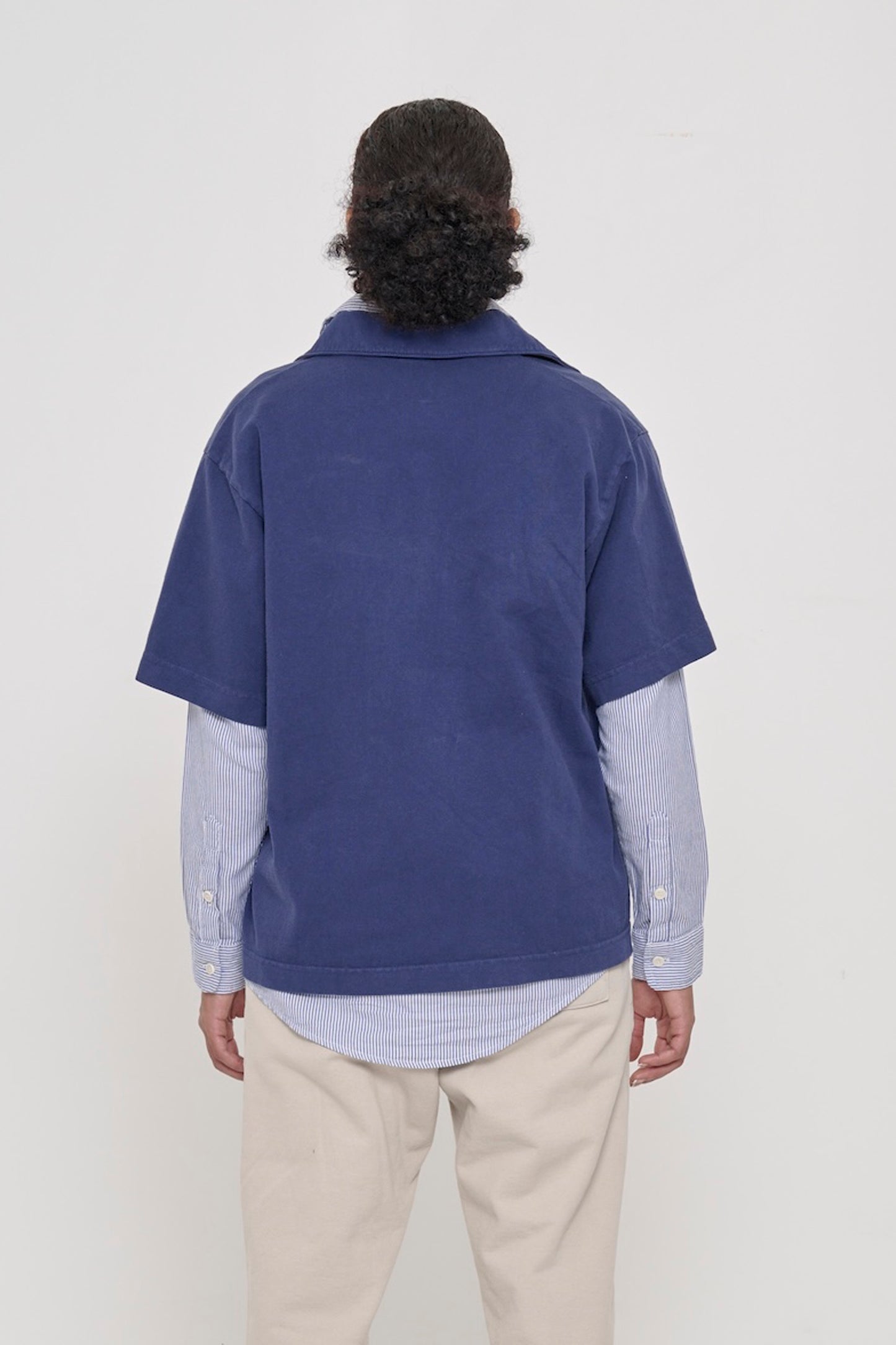 Washed Navy Trash Polo, back view on a person. Roomy and boxy fit throughout.