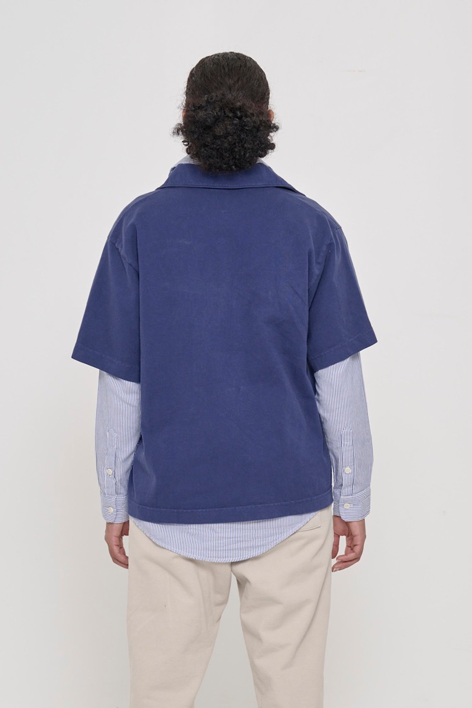 Washed Navy Trash Polo, back view on a person. Roomy and boxy fit throughout.