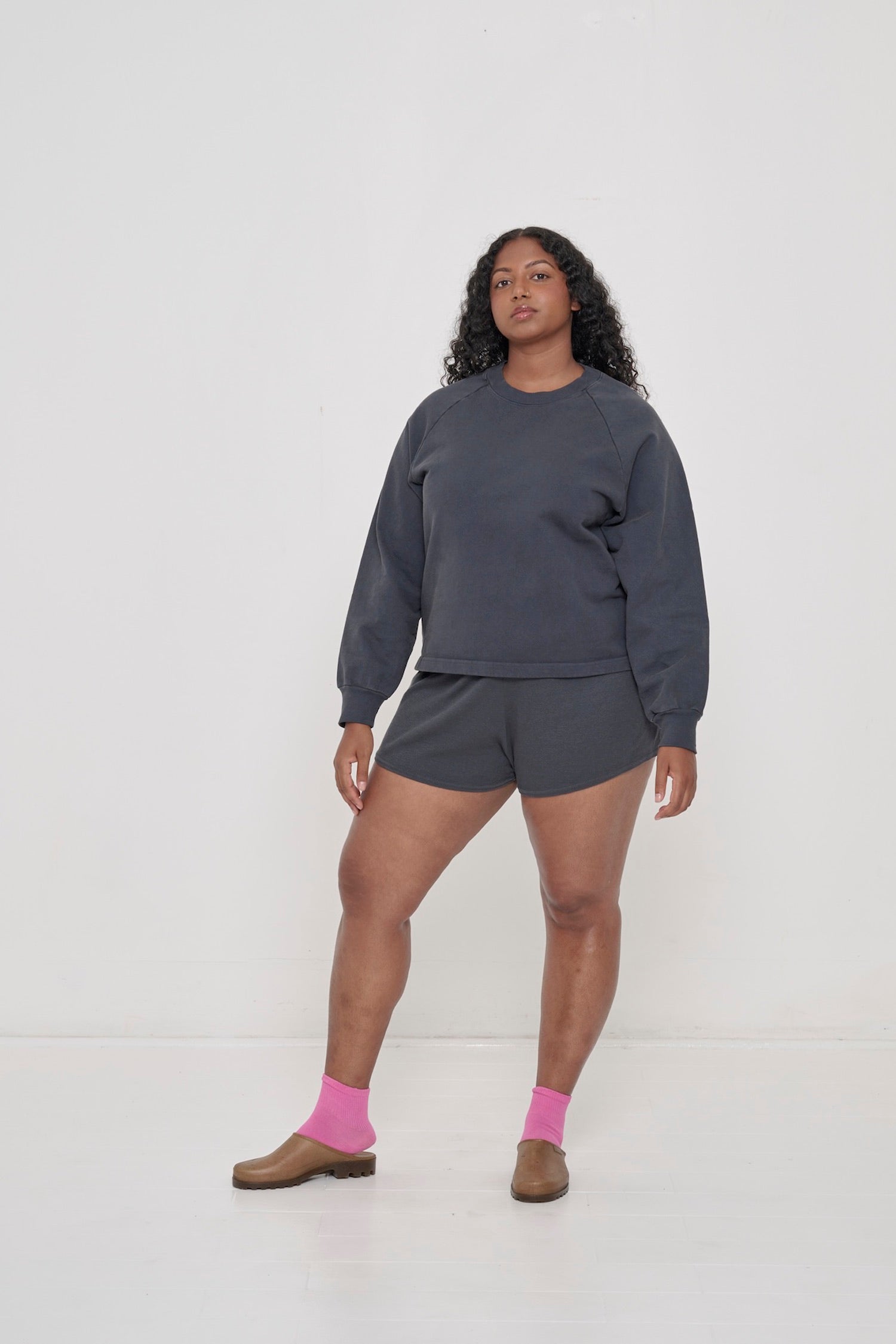 A woman in matching Slate Trash Raglan and Rib Shorts, on arm a few inches from her body to show relaxed sleeve width.