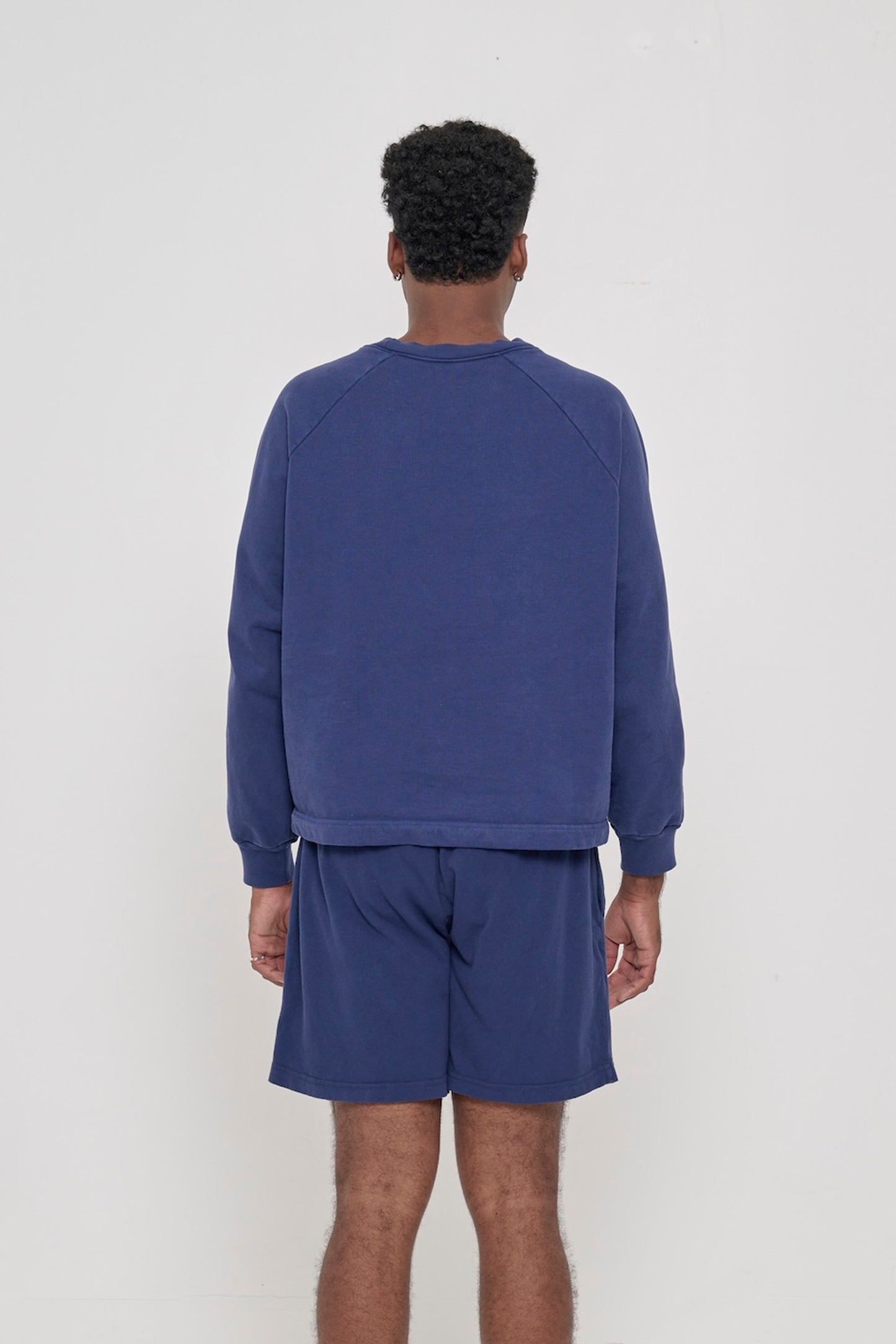 Washed Navy Trash Crewneck, back view on a man. Relaxed and boxy throughout.